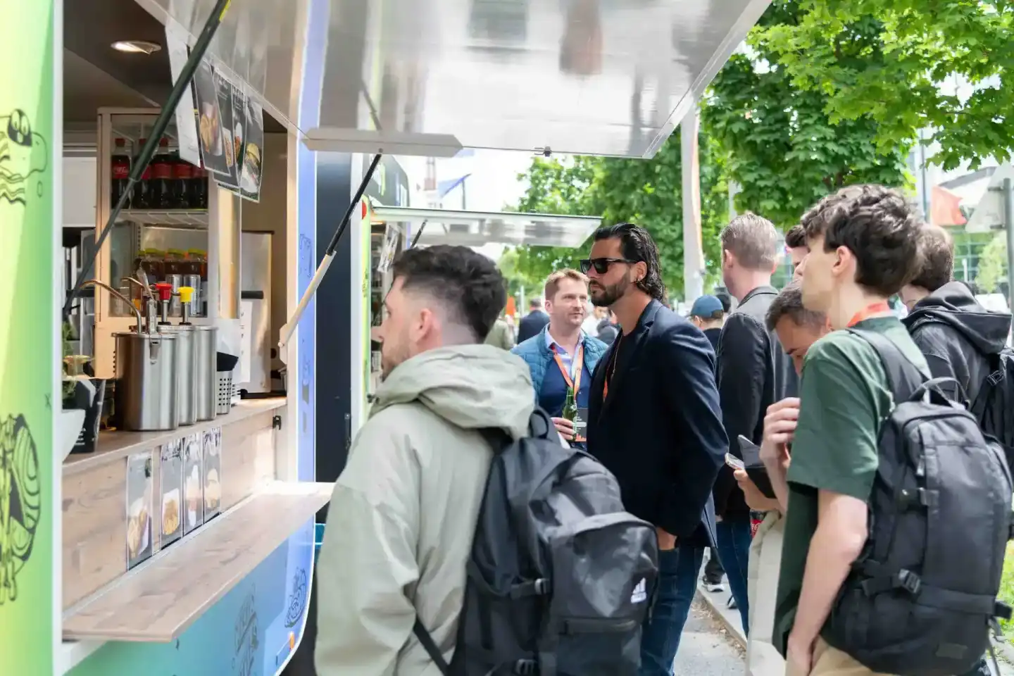 Besucher stehen an einem Food-Truck beim Sonic Summit Event in Wien, Eventfotograf dokumentiert die Szene