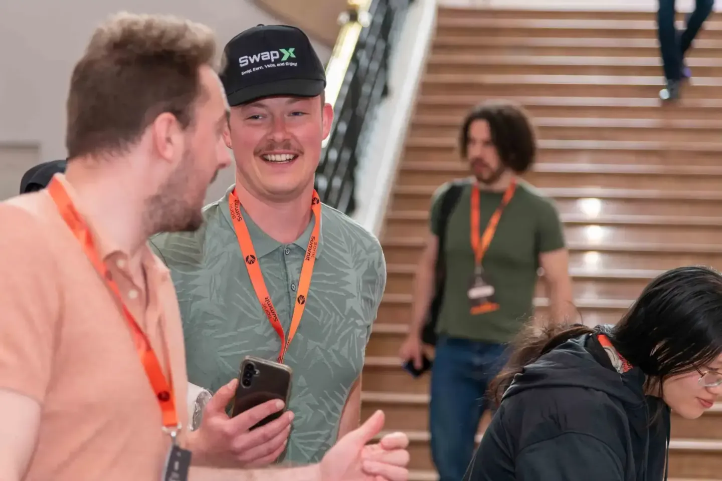 Eventfotograf dokumentiert Networking-Moment beim Sonic Summit in Wien mit Besuchern an einer Treppe
