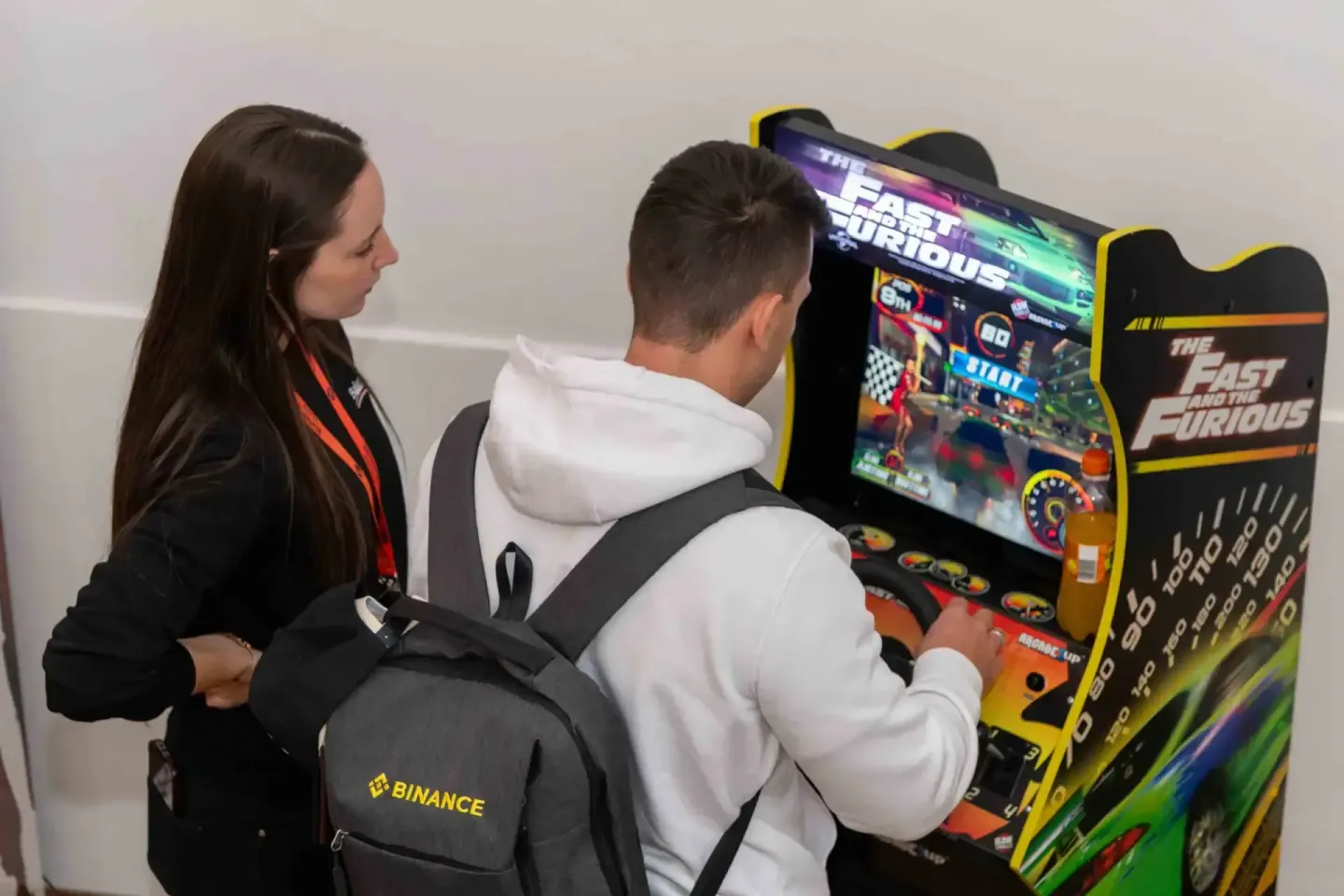 Eventfotograf dokumentiert Besucher beim Spielen an einem Fast and Furious Arcade-Automaten auf der Sonic Summit Wien