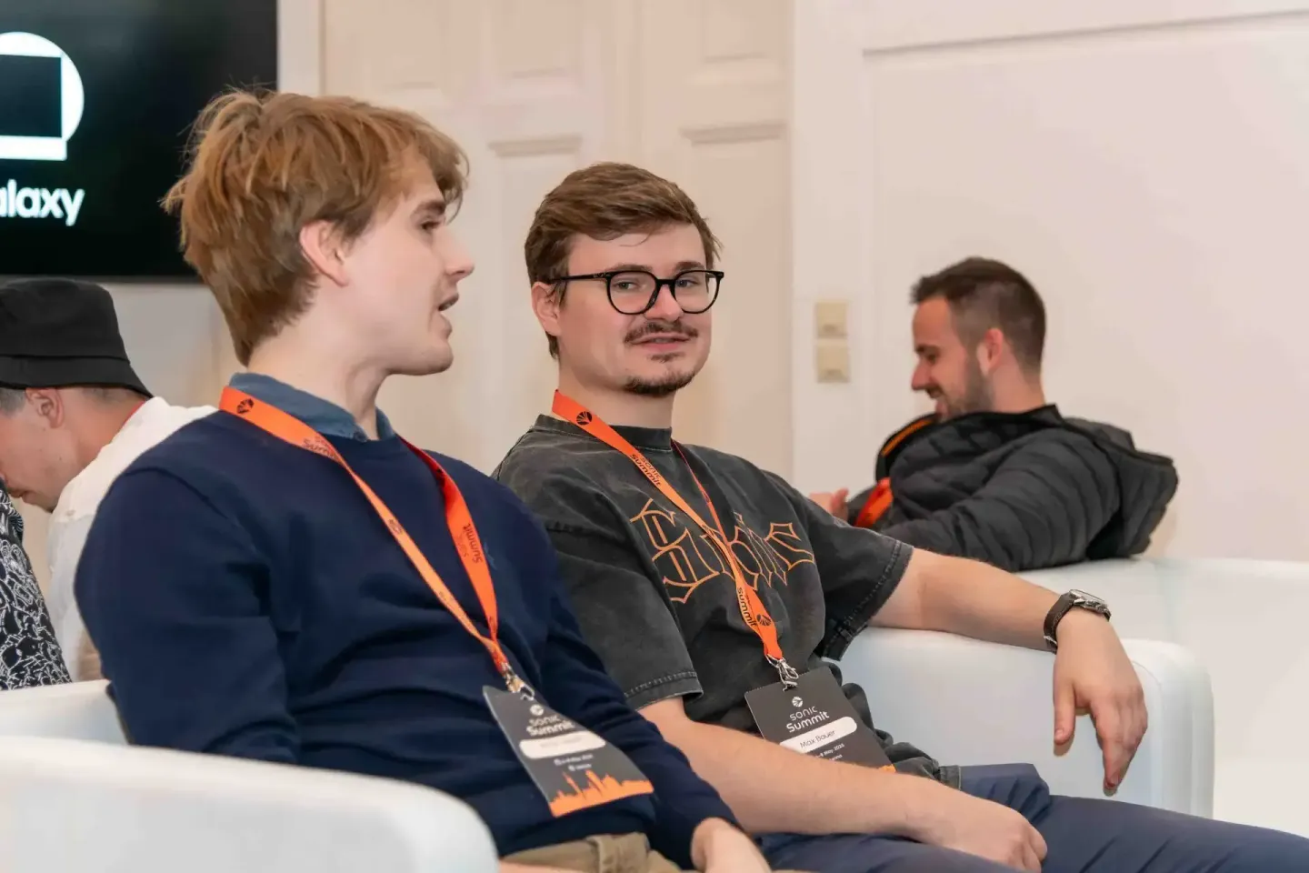 Teilnehmer beim Sonic Summit Event in Wien tragen Lanyards und schauen konzentriert nach vorne – professionelle Eventfotograf