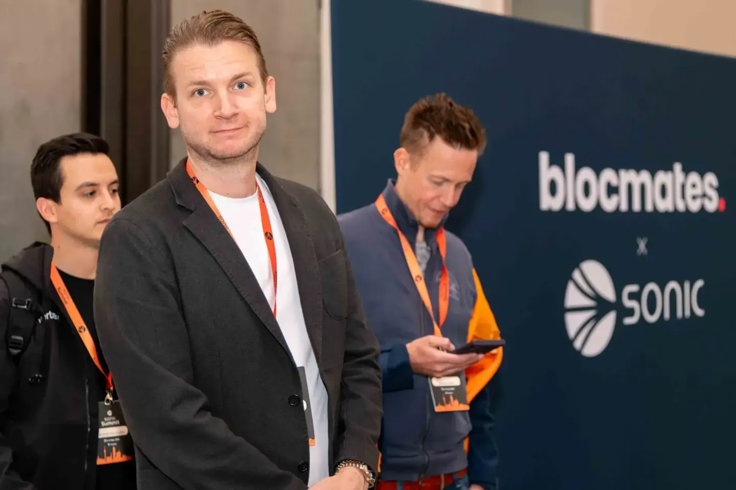 Drei Männer mit orange Lanyards beim Sonic Summit Event – professionelle Eventfotografie Wien