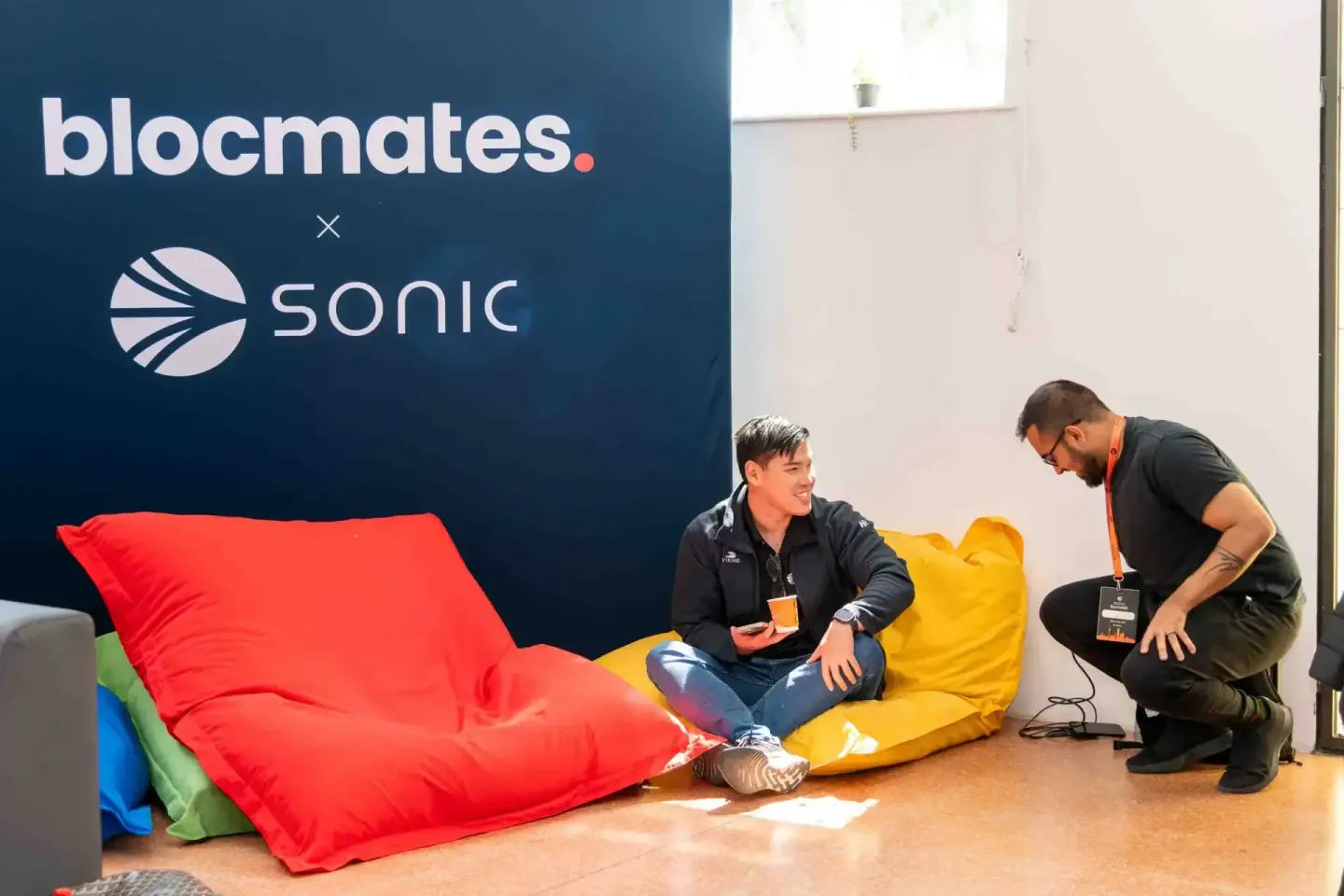 Zwei Personen sitzen auf bunten Sitzsäcken beim Sonic Summit Event vor der Blocmates x Sonic Wand - Eventfotografie Wien