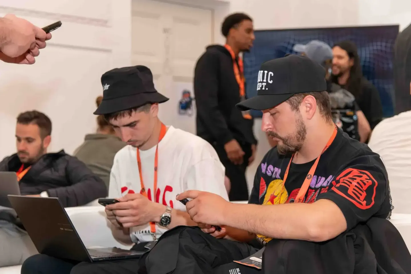 Teilnehmer beim Sonic Summit Event in Wien nutzen Smartphones und Laptops während einer Networking-Session, Eventfotograf dok