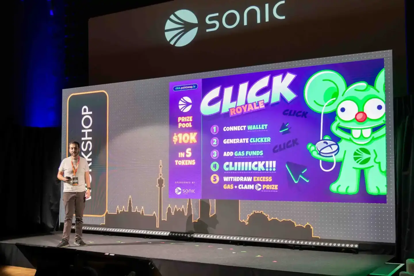 Eventfotograf präsentiert Click Royale Projekt auf großer Bühne beim Sonic Summit mit Publikum und Displayscreen