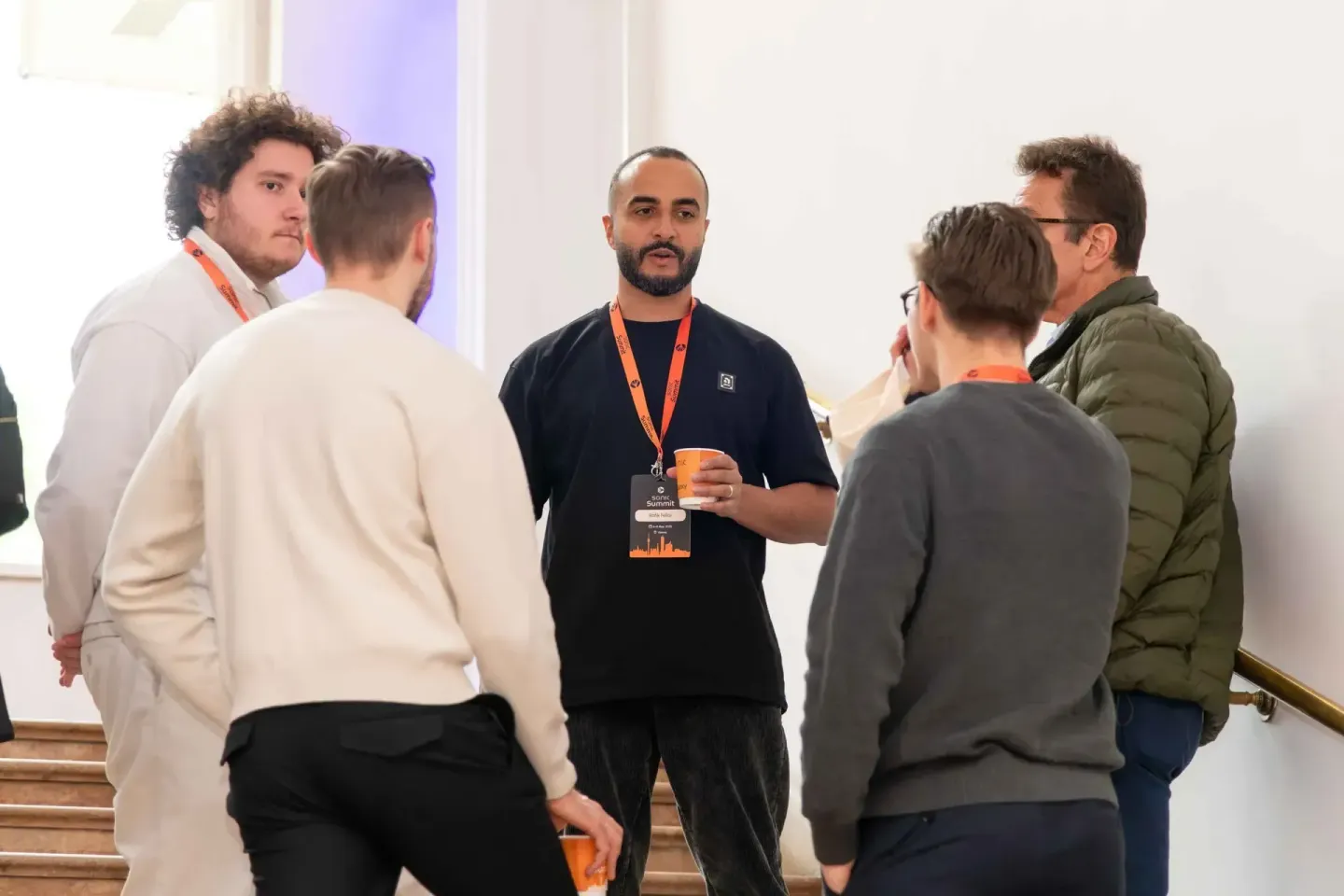 Eventfotograf Wien dokumentiert Diskussionsrunde beim Sonic Summit mit fünf Teilnehmern in moderner Veranstaltungshalle