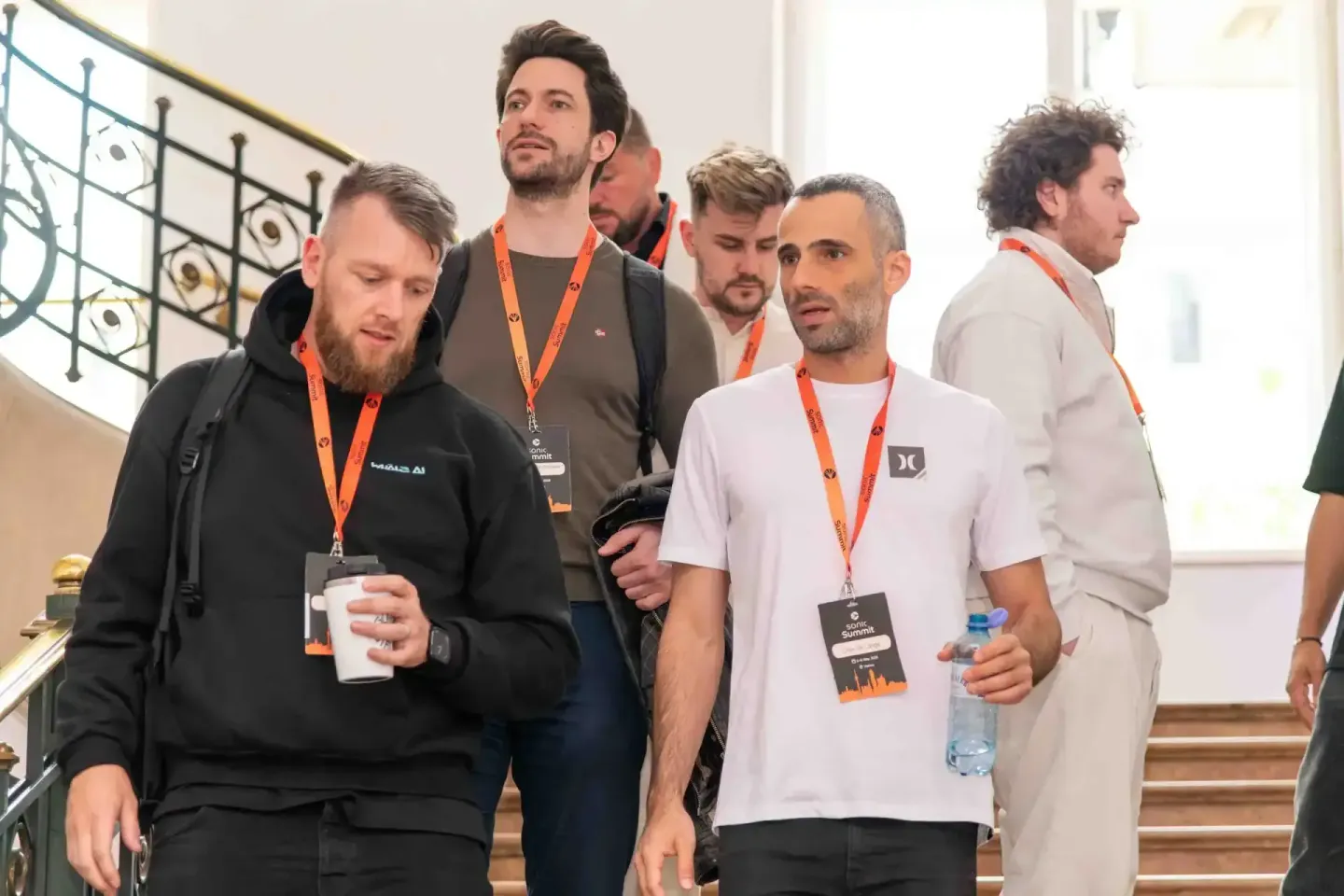 Gruppe von Teilnehmern mit orange Lanyards beim Sonic Summit Event in Wien, Eventfotograf dokumentiert Networking-Momente