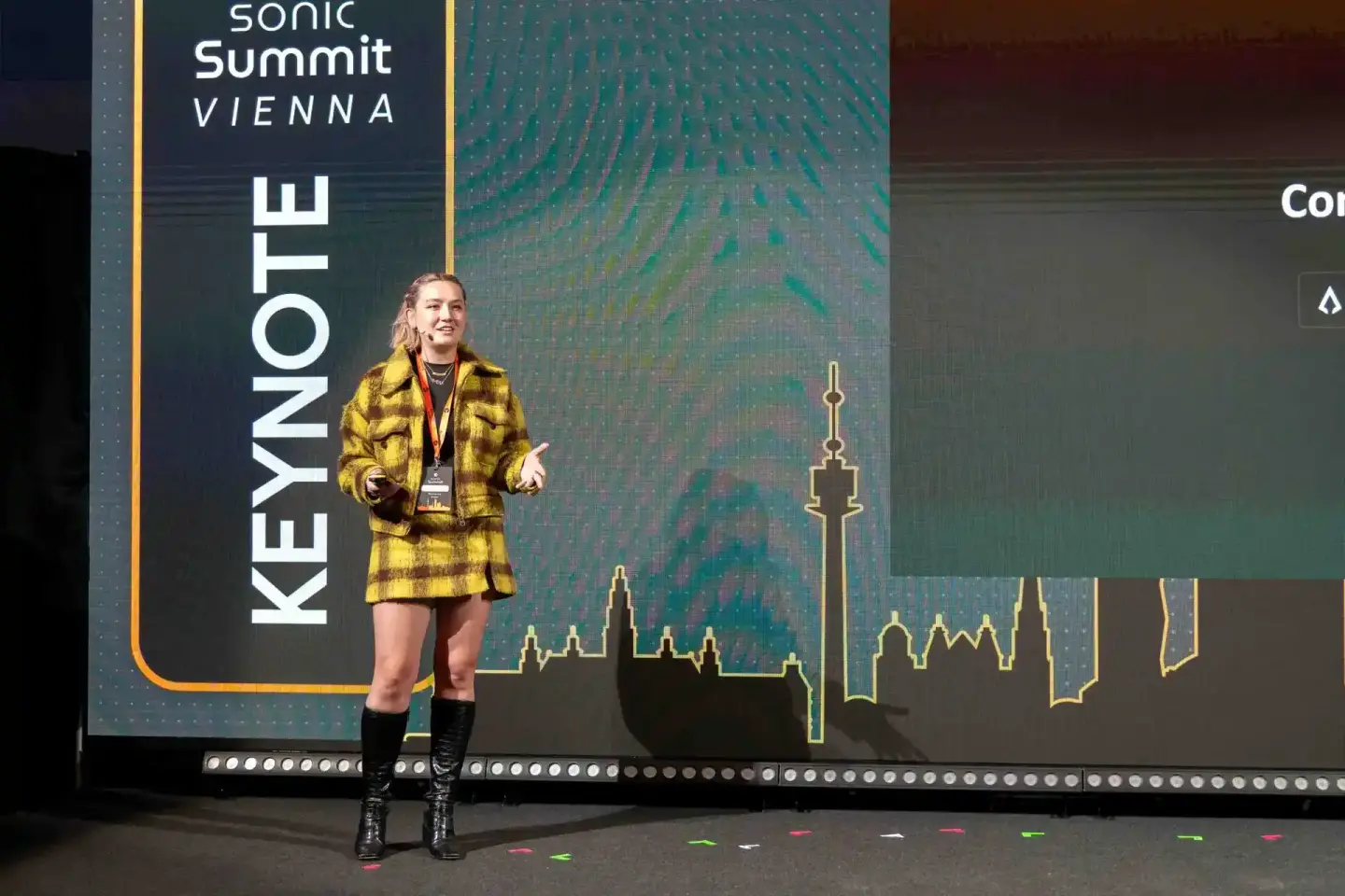 Speakerin im gelben Blazer auf der Sonic Summit Vienna Bühne, professionelle Eventfotografie Wien