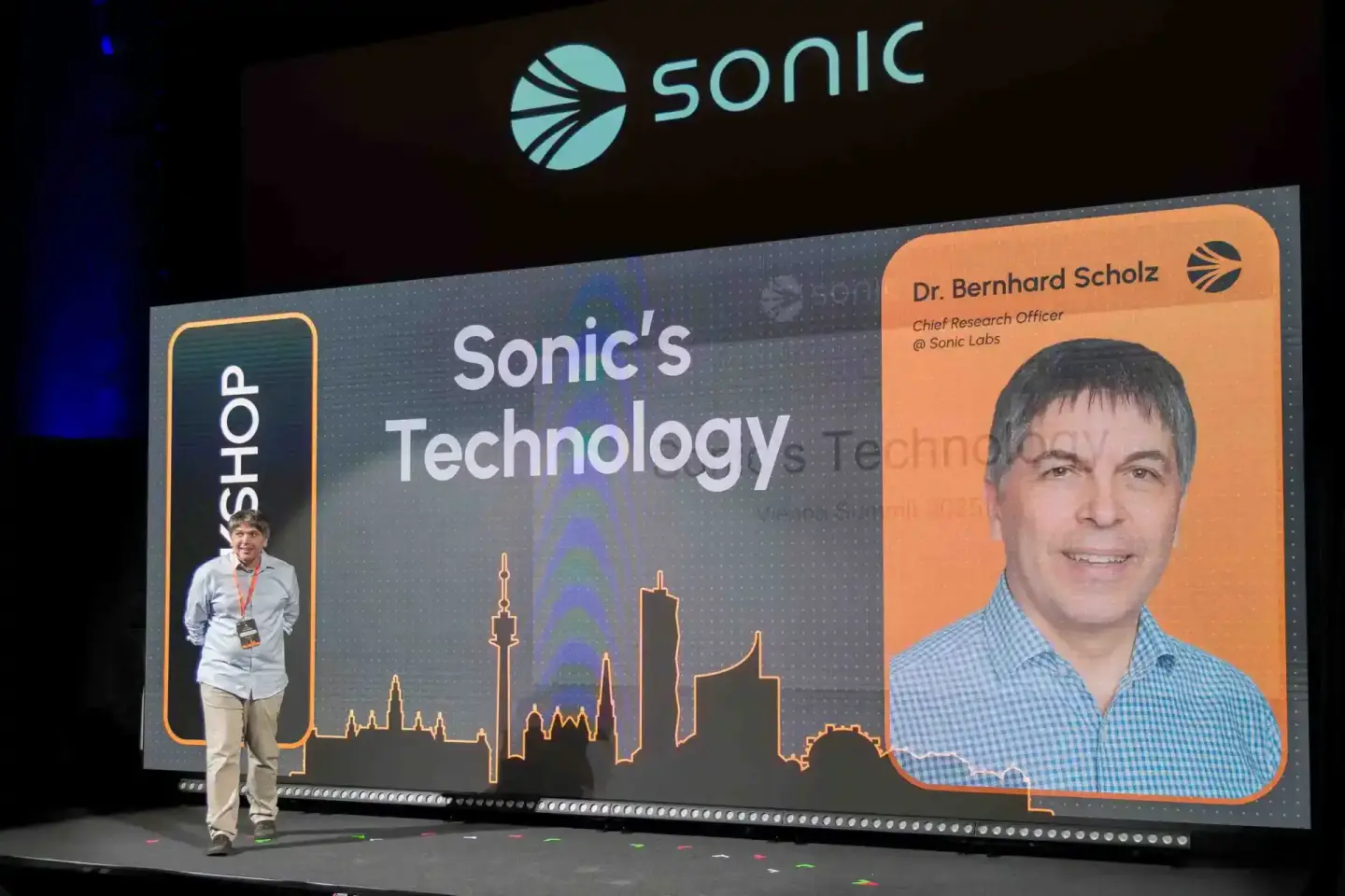 Eventfotograf dokumentiert Präsentation auf Sonic Summit: Dr. Bernhard Scholz, Chief Research Officer, auf großer Bühne mit S