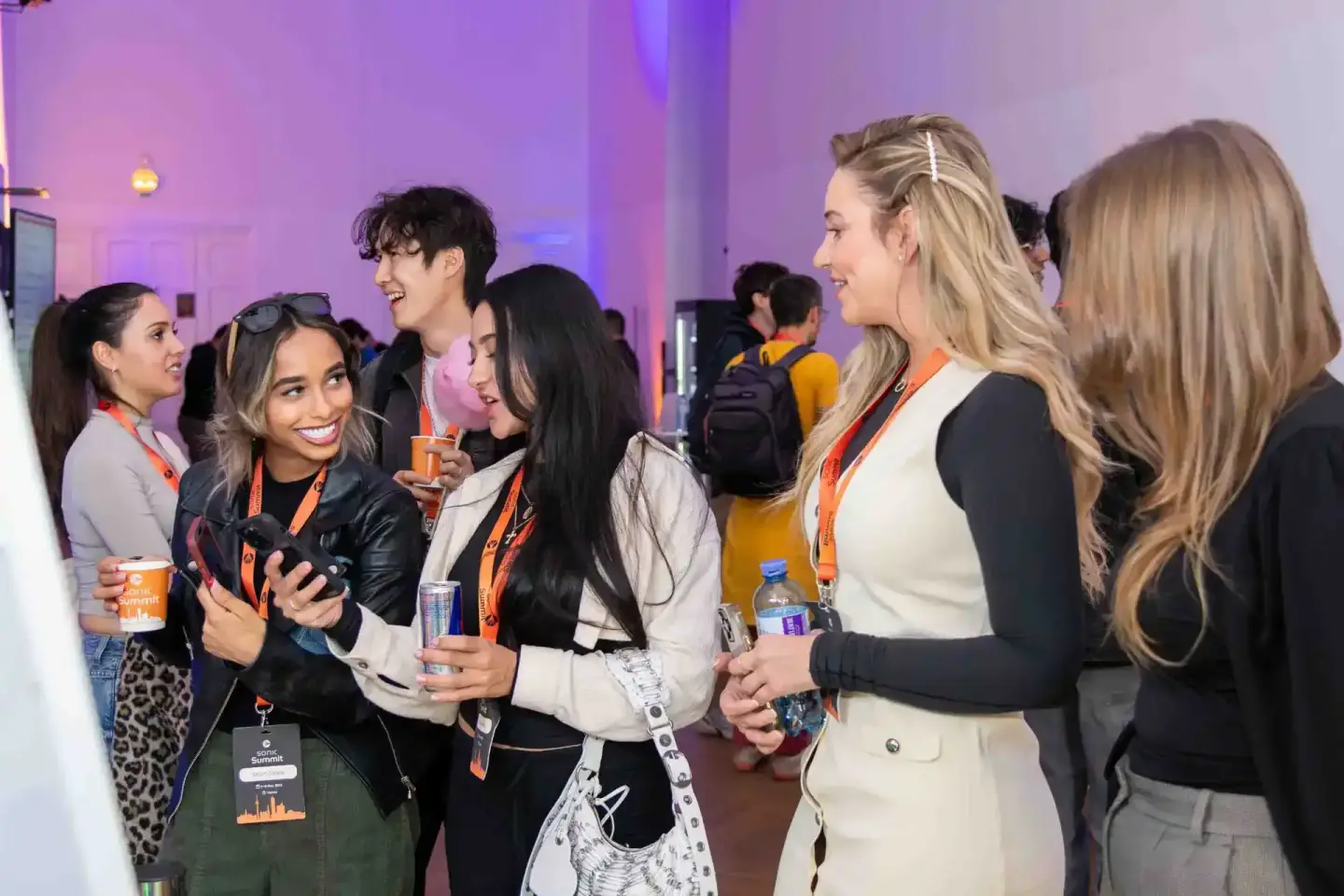 Gruppenfoto von lächelnden Besuchern mit Lanyards beim Sonic Summit Event, Eventfotograf Wien dokumentiert Netzwerking-Moment
