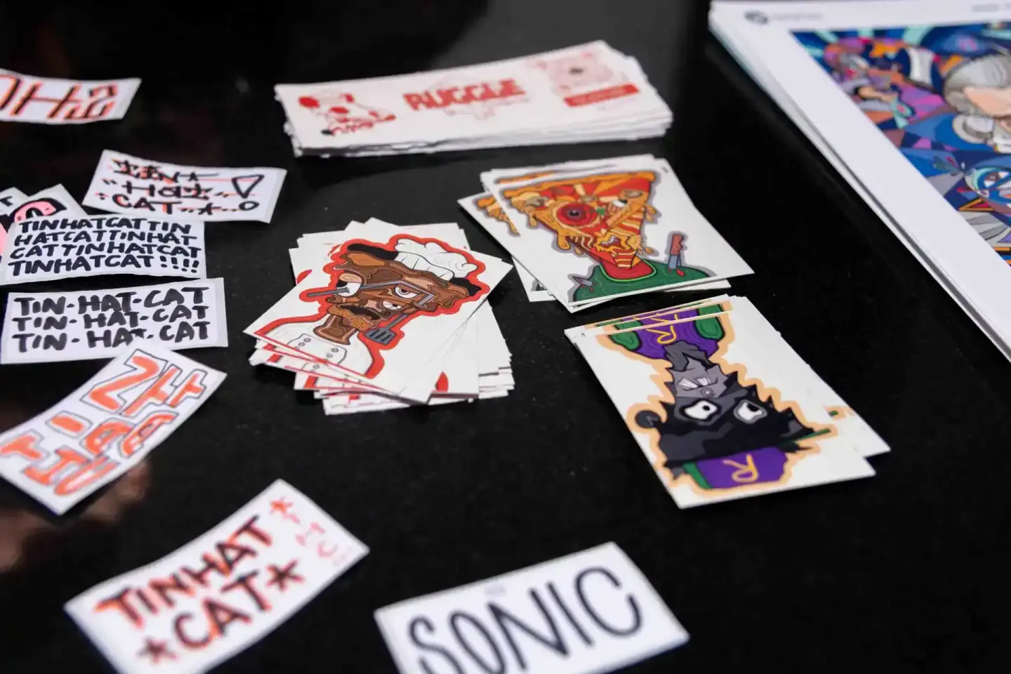 Bunte Sticker und Karten mit Sonic-Motiven auf schwarzem Untergrund bei der Sonic Summit Veranstaltung - Eventfotografie Wien