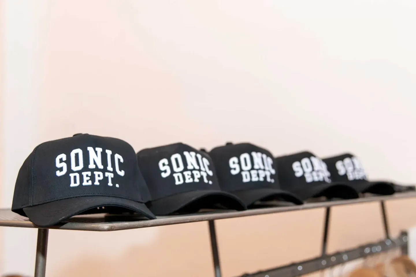 Reihe schwarzer SONIC DEPT. Caps auf einer Stange - Eventfotografie Wien eines Corporate Giveaways