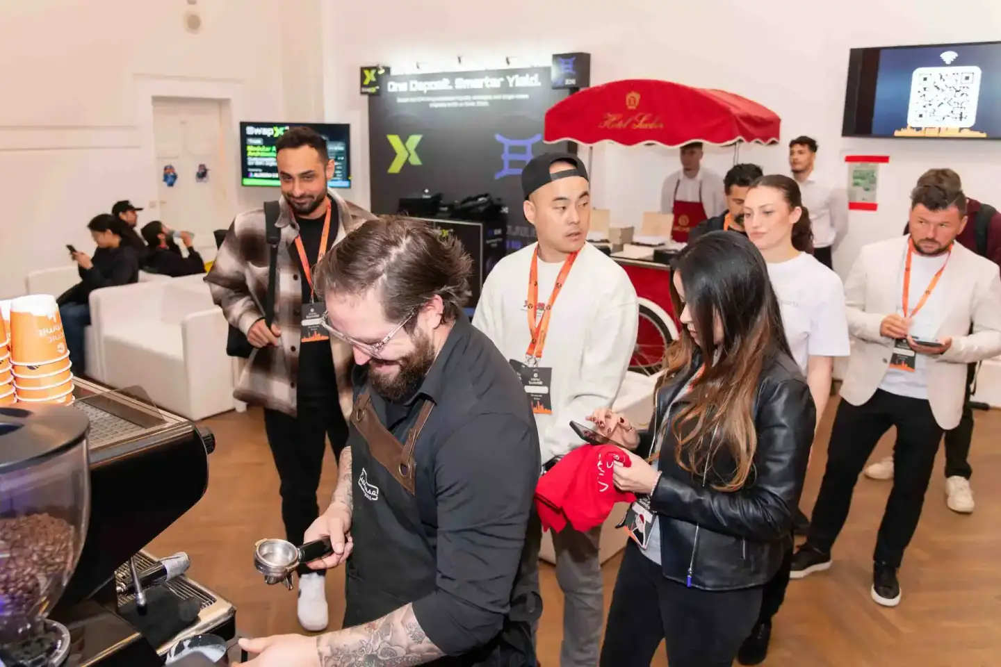 Eventfotograf dokumentiert Sonic Summit Wien: Besucher an Espresso-Bar mit rotem Schirm, Networking im modernen Veranstaltung