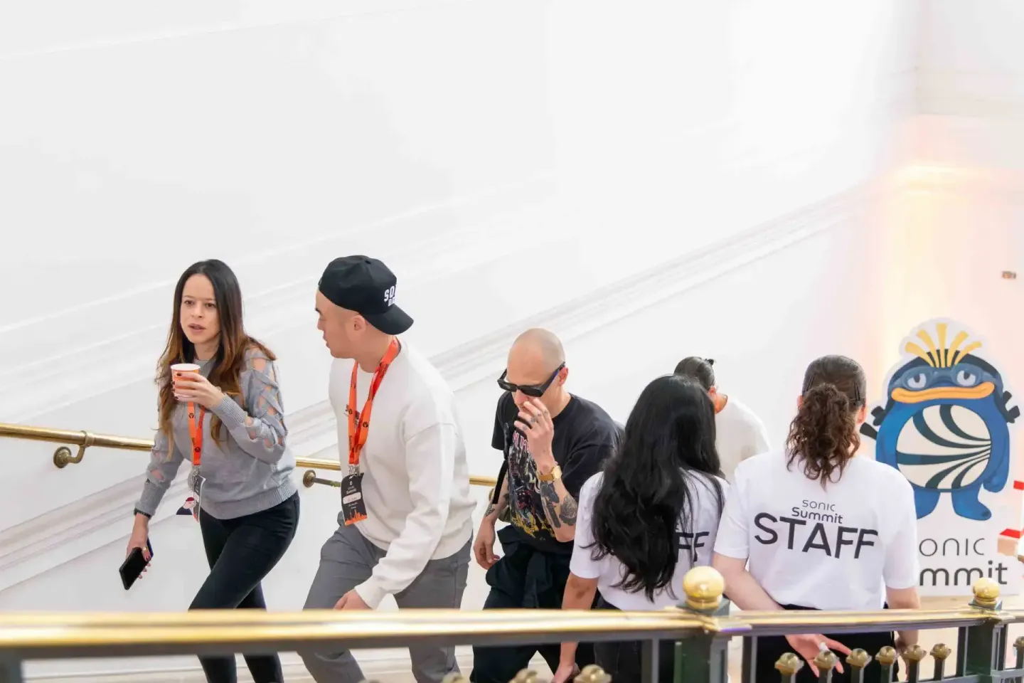 Eventfotograf dokumentiert Sonic Summit mit Teilnehmern und Staff-Mitgliedern auf einer modernen Treppe mit weißem Hintergrun