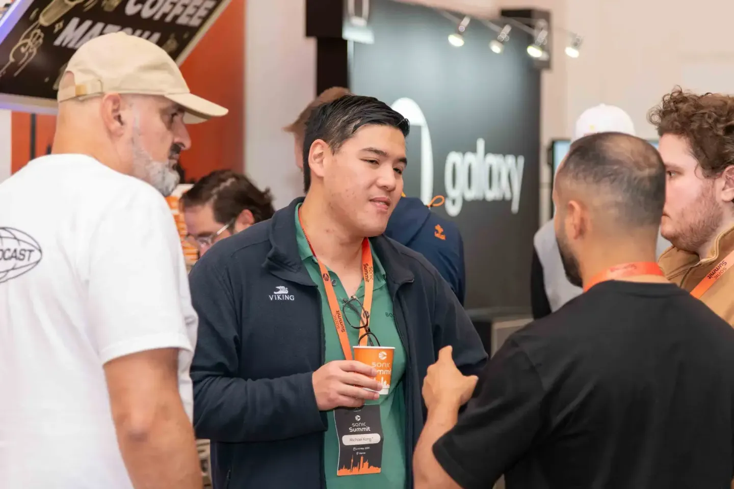 Eventfotograf dokumentiert Networking-Moment beim Sonic Summit in Wien mit Besuchern und Ausstellern