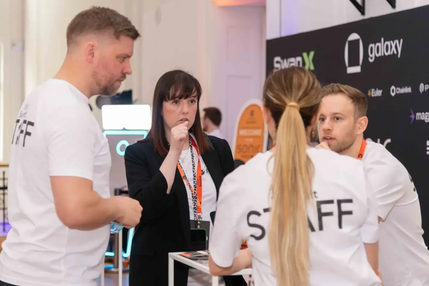 Eventfotograf dokumentiert Gespräch zwischen Mitarbeitern und Besucherin mit Lanyard auf der Sonic Summit Konferenz in Wien