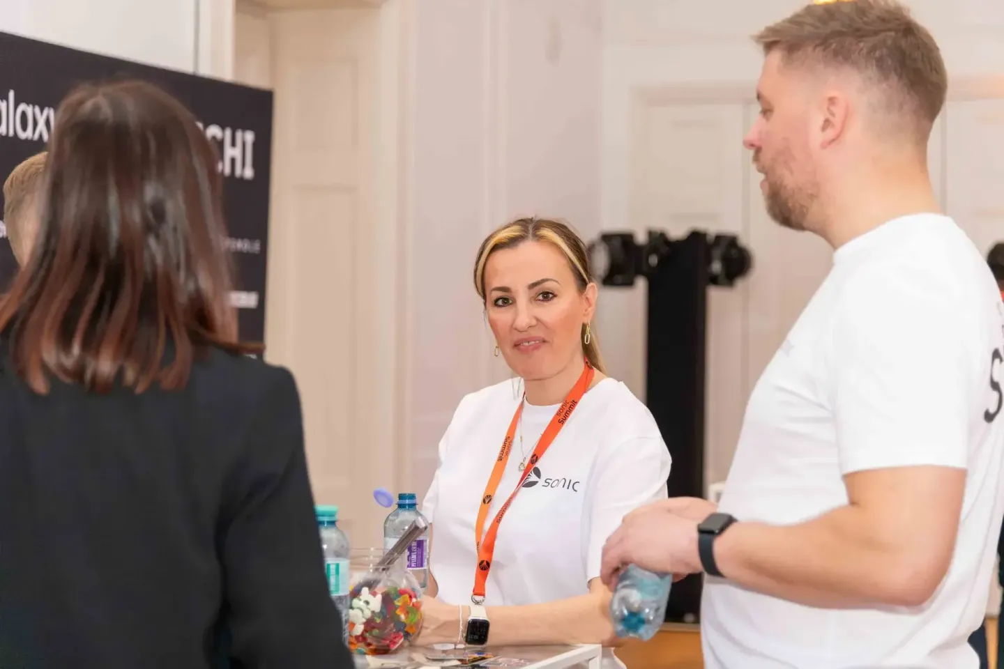 Eventfotograf dokumentiert Networking-Gespräch bei Sonic Summit Wien mit drei Personen an einem Tisch