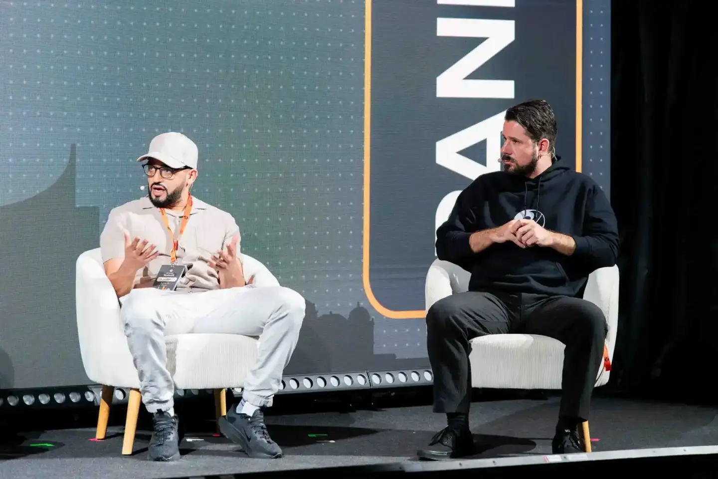 Zwei Sprecher diskutieren auf der Sonic Summit Bühne vor digitalem Hintergrund – Eventfotografie Wien