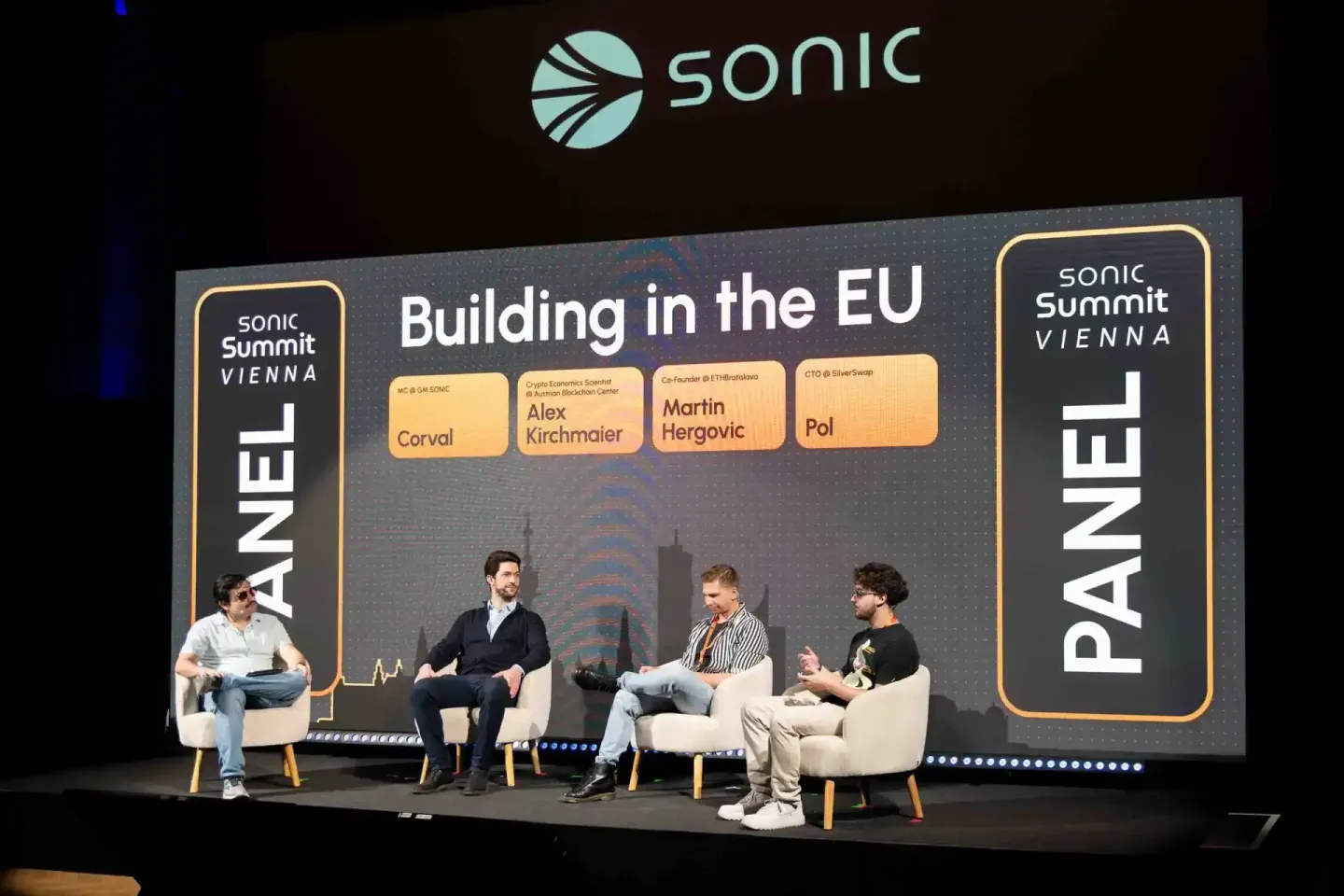Panel-Diskussion "Building in the EU" beim Sonic Summit Vienna mit vier Sprechern auf der Bühne, professionelle Eventfotograf