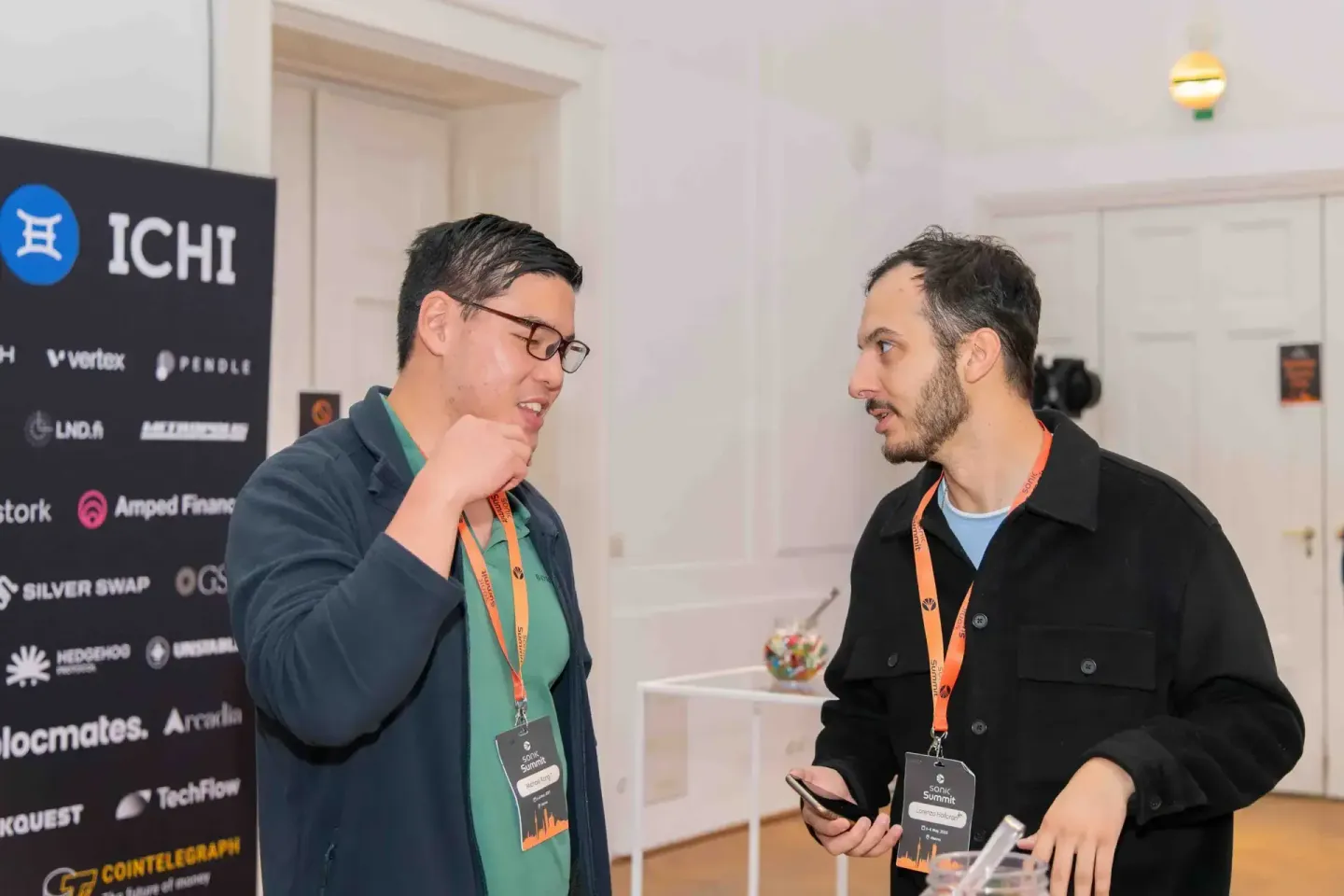 Zwei Männer mit Lanyards im Gespräch beim Sonic Summit Event, Eventfotografie Wien dokumentiert Netzwerken