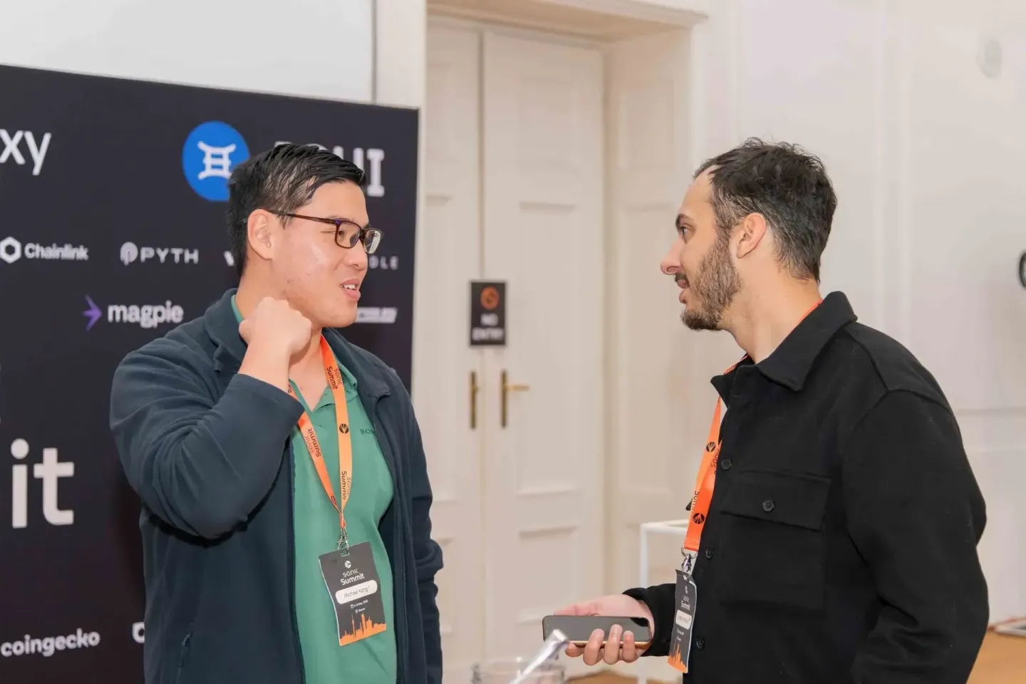 Zwei Männer mit Akkreditierungen unterhalten sich beim Sonic Summit Event, Eventfotografie Wien