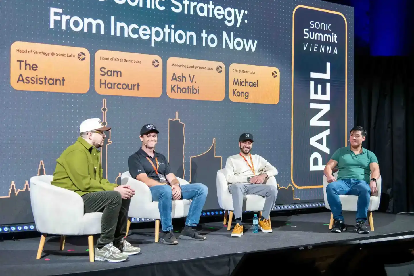 Vier Sprecher sitzen auf einer Bühne beim Sonic Summit Vienna Panel über die Sonic-Strategie. Professionelle Eventfotografie 