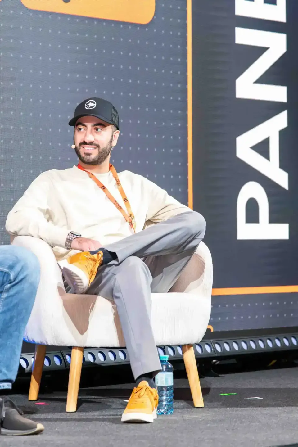 Sprecher beim Sonic Summit sitzt auf Stuhl vor großer Bühne, professionelle Eventfotografie Wien