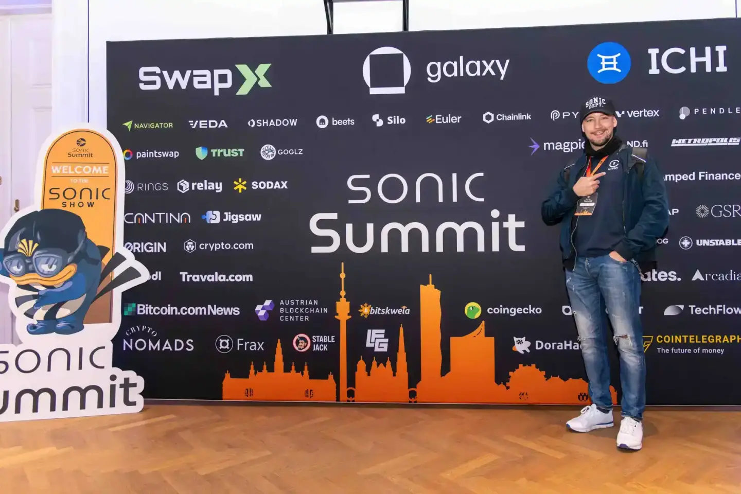 Eventfotograf dokumentiert Teilnehmer beim Sonic Summit in Wien vor schwarzer Bühne mit orange Skyline
