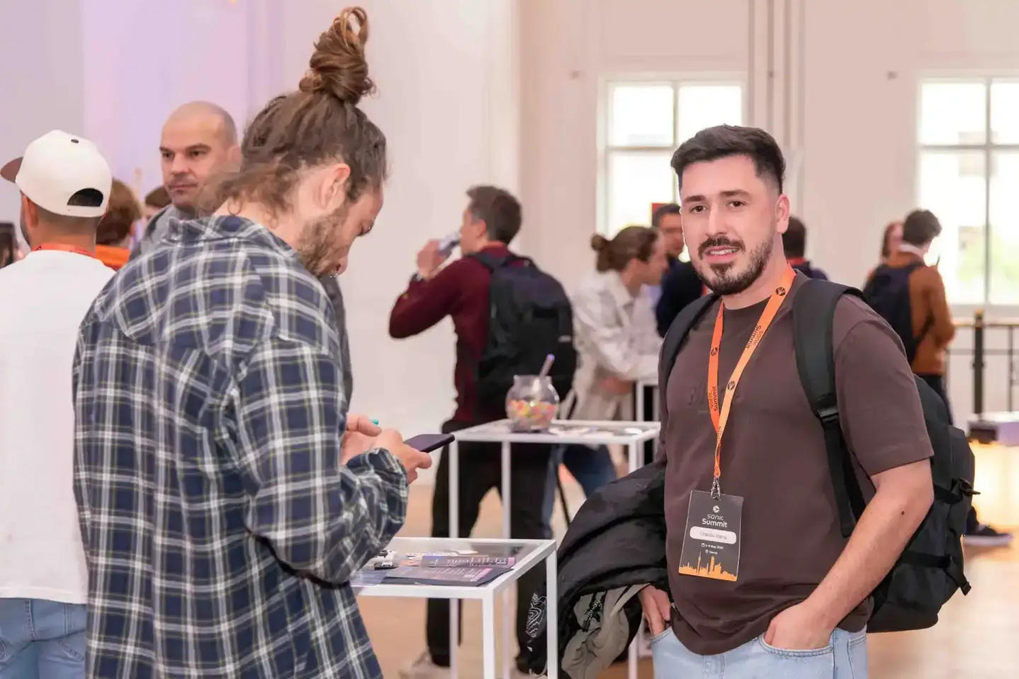 Eventfotograf dokumentiert Networking beim Sonic Summit in Wien – Besucher im Austausch in heller Eventhalle
