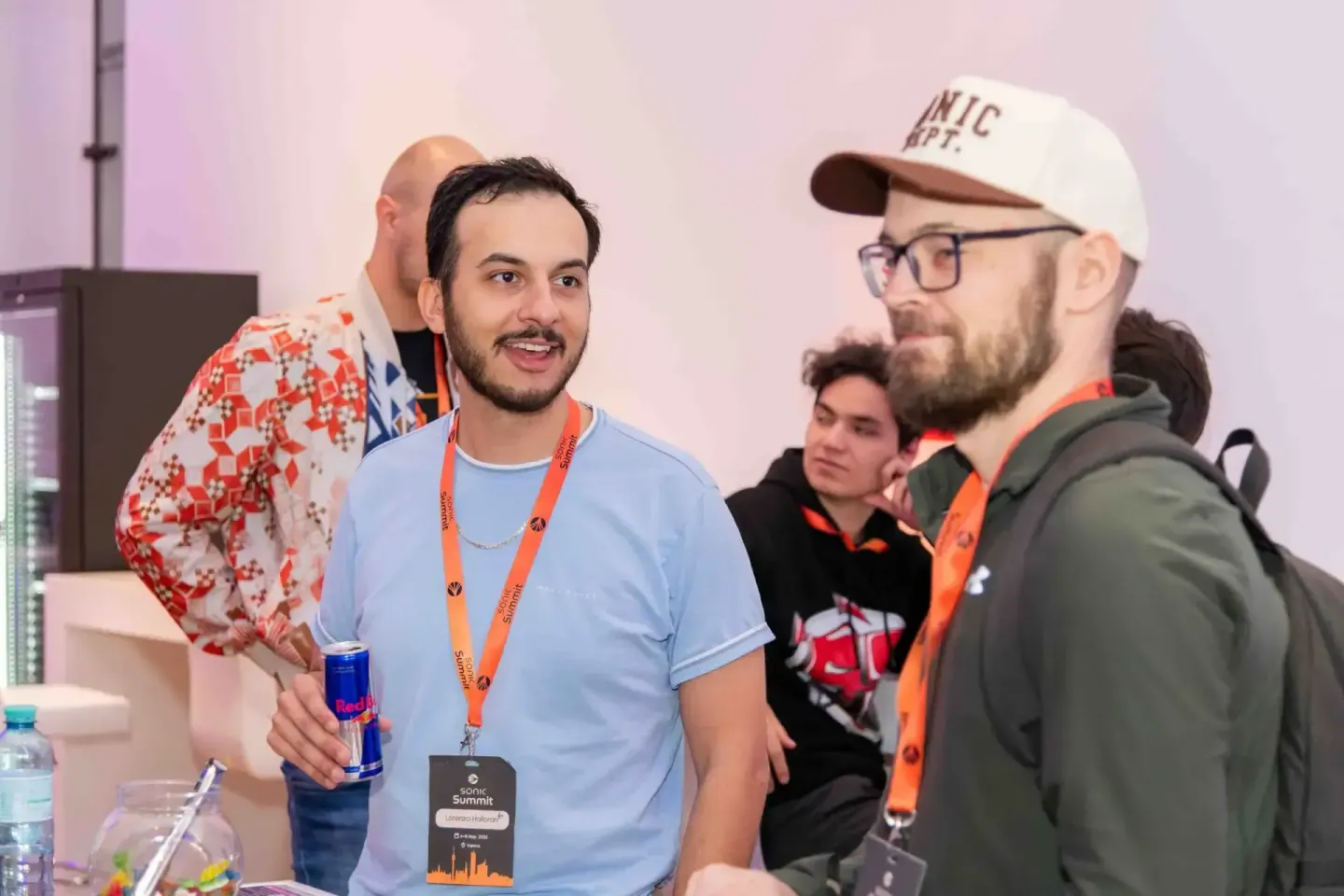 Eventfotograf dokumentiert Networking-Moment beim Sonic Summit mit mehreren Teilnehmern in lockerer Atmosphäre