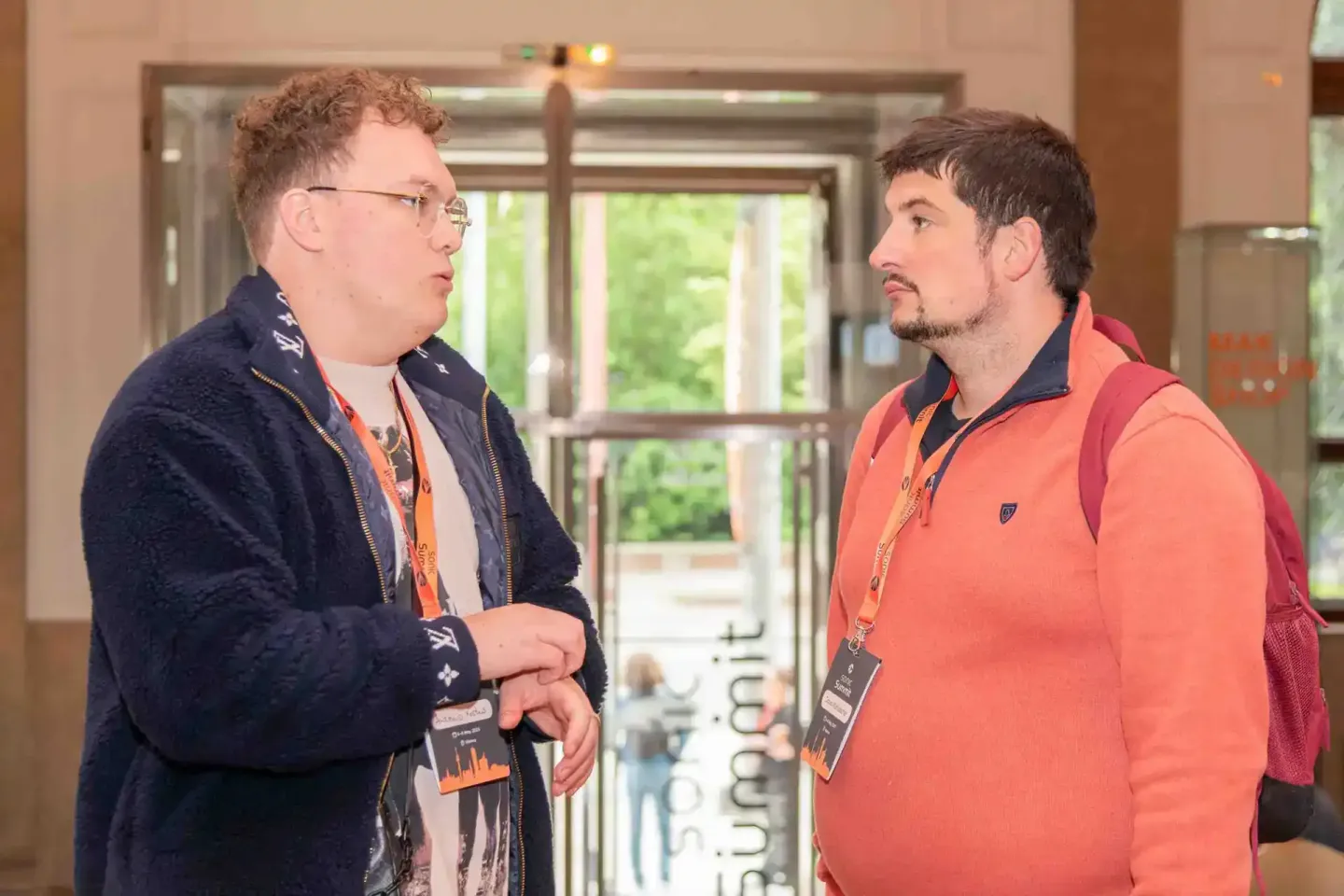 Zwei Männer im Gespräch bei der Sonic Summit Veranstaltung in Wien, beide tragen Ausweisbänder