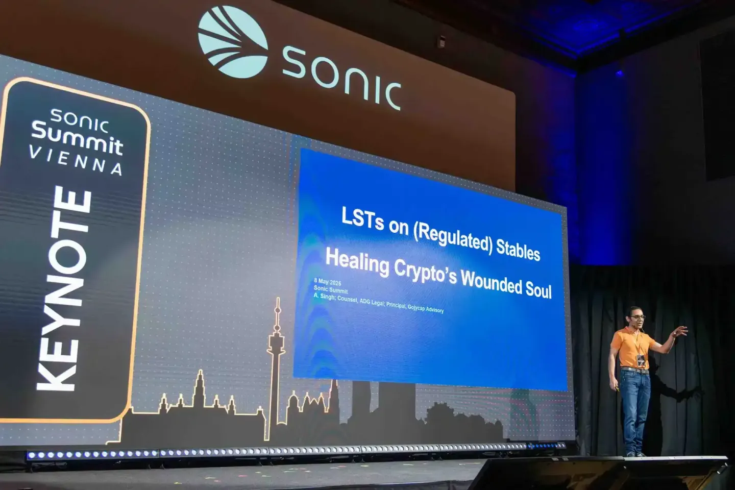 Sprecher in orangem Shirt bei der Sonic Summit Vienna präsentiert Vortrag über LSTs und Stablecoins – Eventfotografie Wien