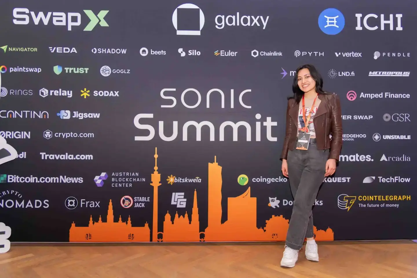 Eventfotografin vor der beleuchteten Skyline des Sonic Summit in Wien mit Sponsorenlogos