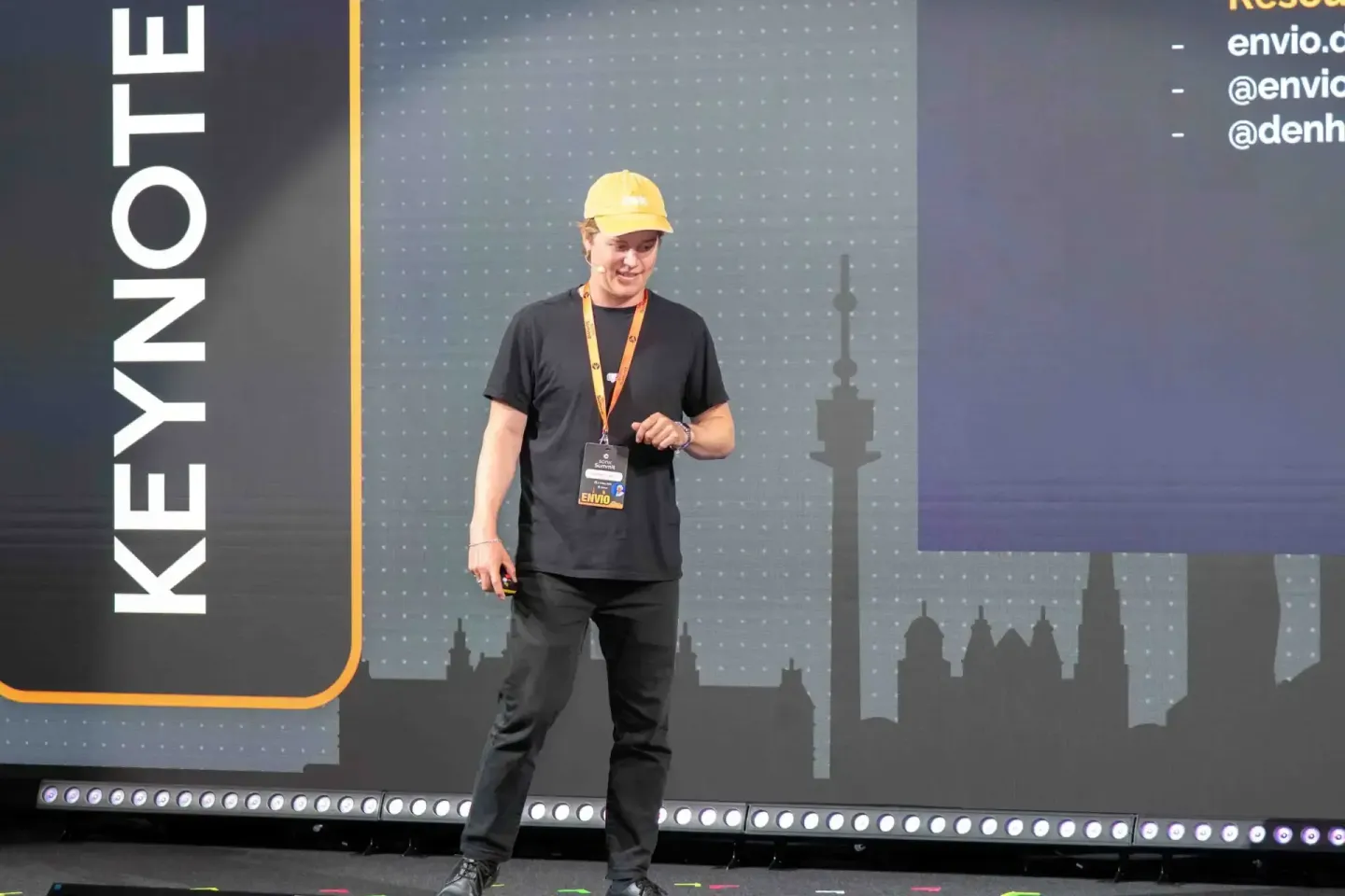 Speaker auf der Sonic Summit Bühne in Wien trägt gelbe Kappe und schwarzes Shirt mit Lanyard während Präsentation