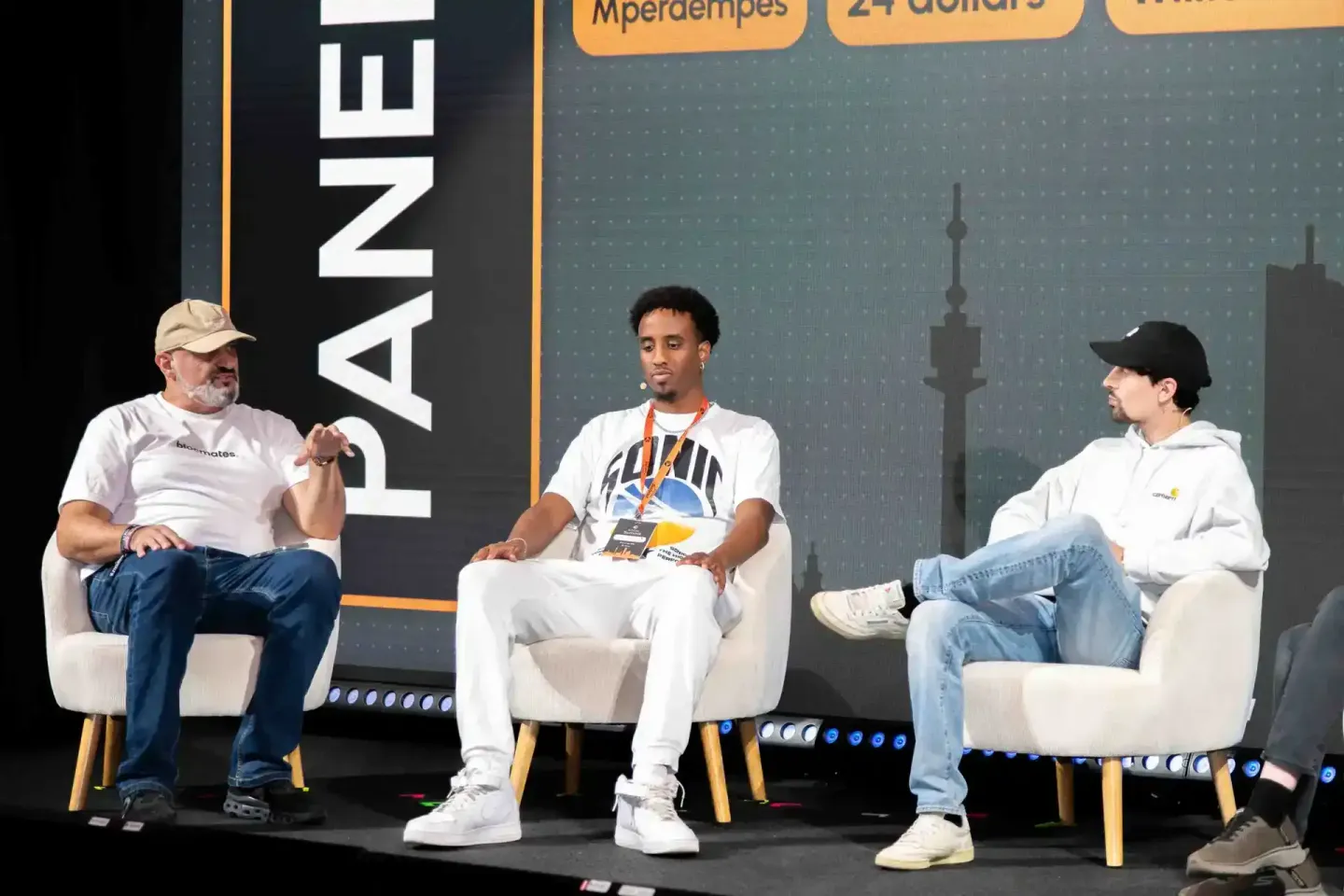 Drei Männer sitzen auf einer Bühne beim Sonic Summit in Wien und diskutieren. Professionelle Eventfotografie Wien.