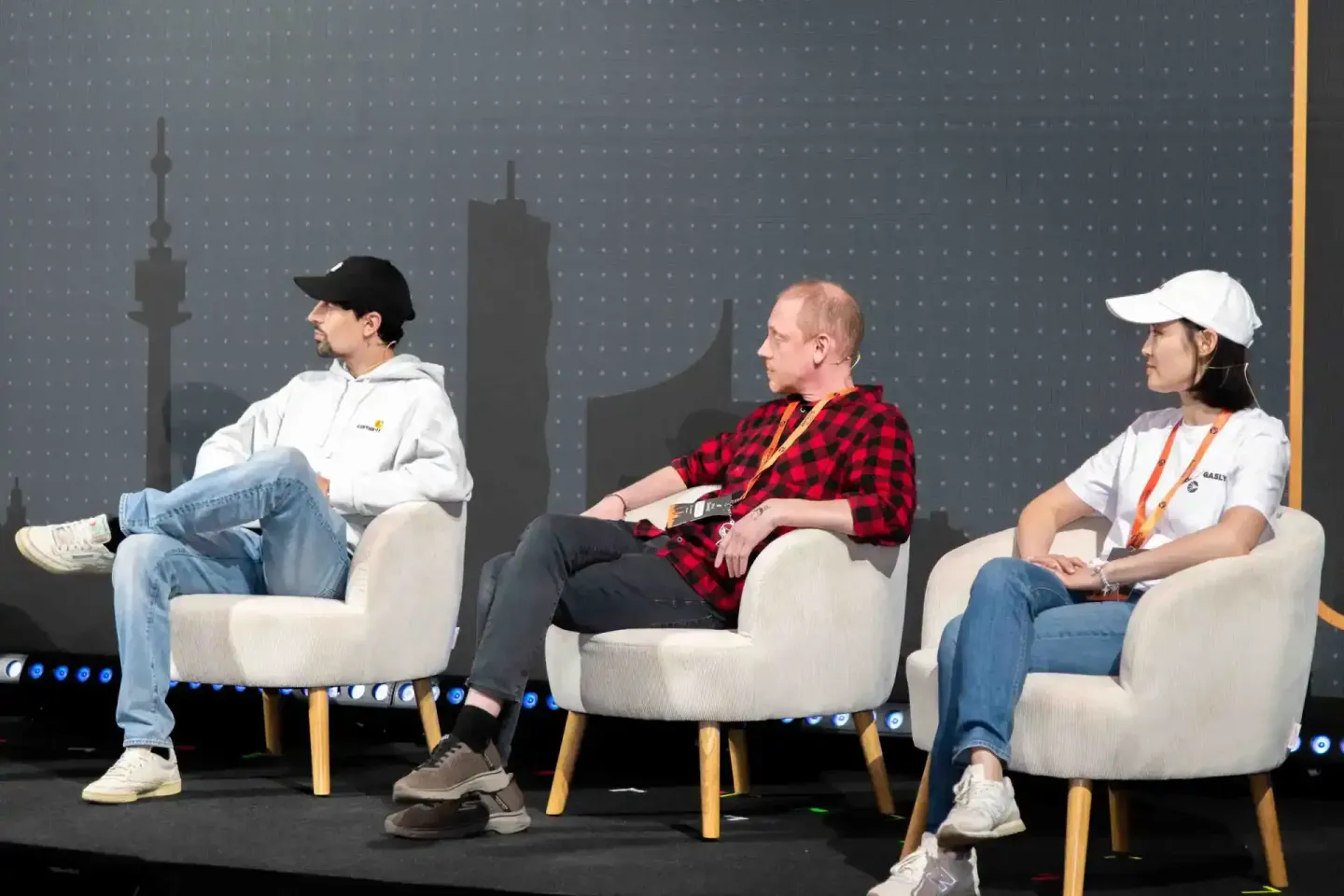 Drei Panelisten sitzen auf der Sonic Summit Bühne vor Wiener Skyline. Eventfotografie Wien dokumentiert die Diskussionsrunde.