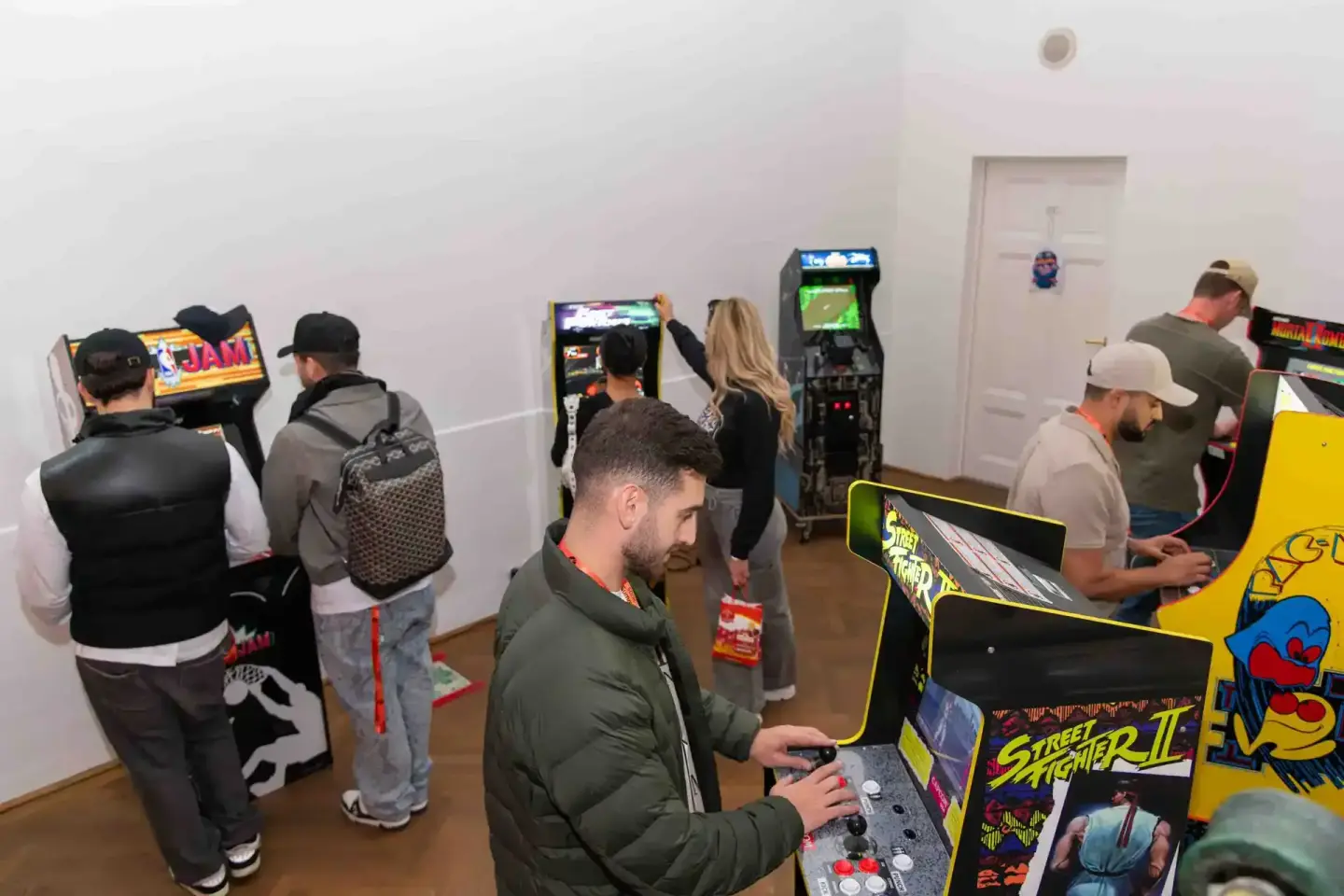 Besucher spielen an klassischen Arcade-Spielautomaten beim Sonic Summit Event in Wien, Eventfotografie