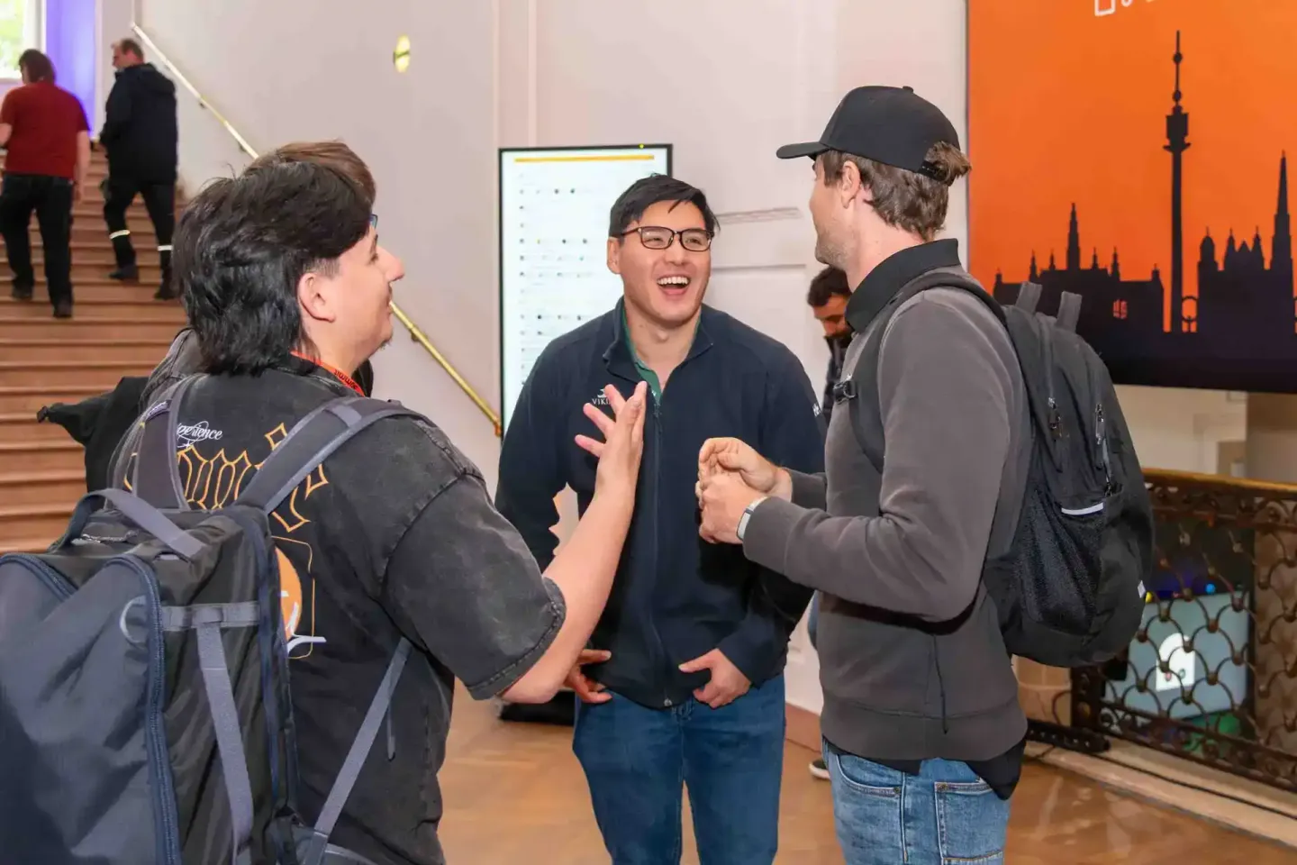 Drei Personen im Gespräch bei Sonic Summit Event in Wien, Eventfotografie dokumentiert Networking-Moment