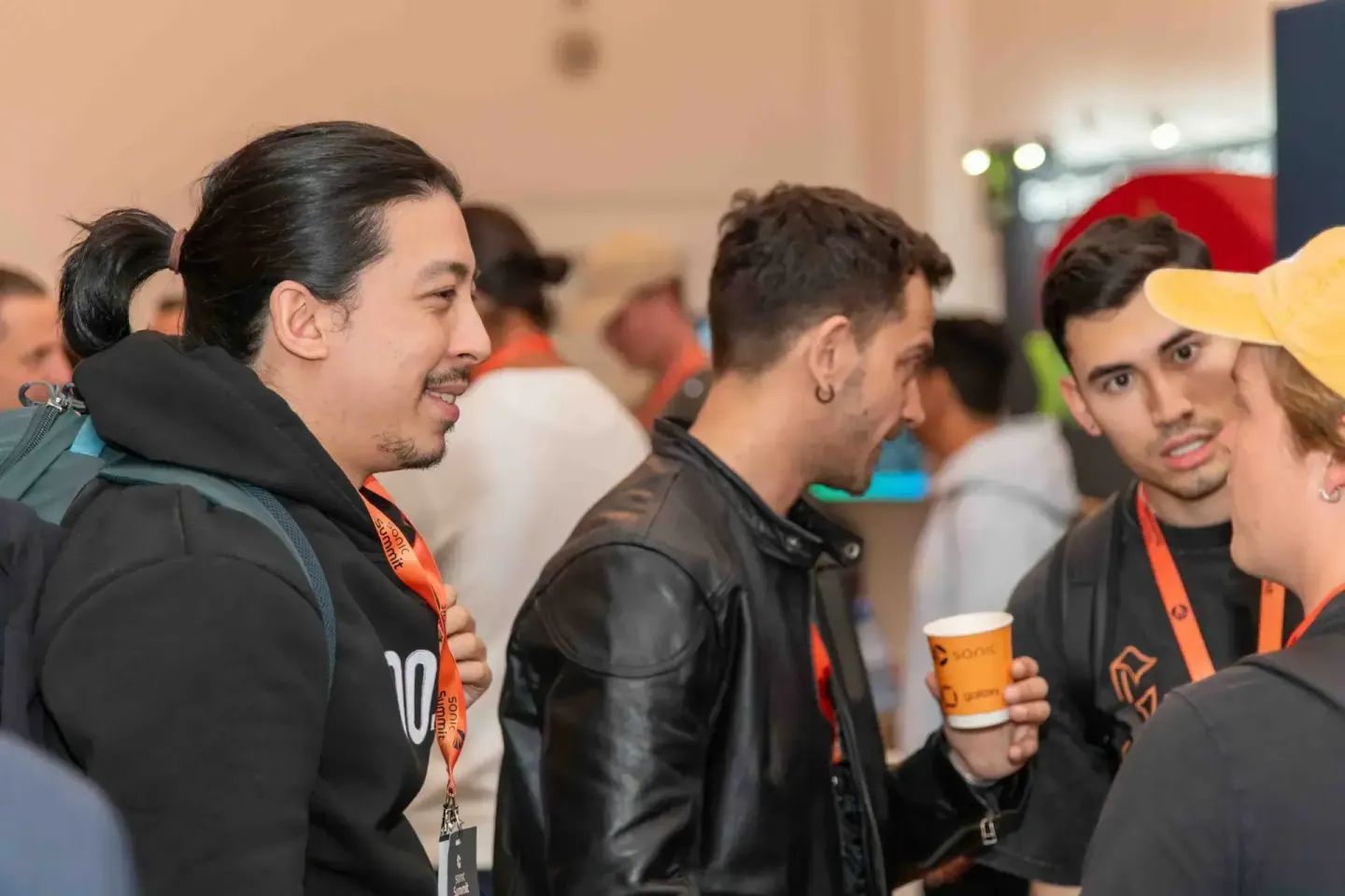 Besucher beim Sonic Summit Event in Wien mit Lanyards und Getränken im Gespräch - Eventfotografie Wien