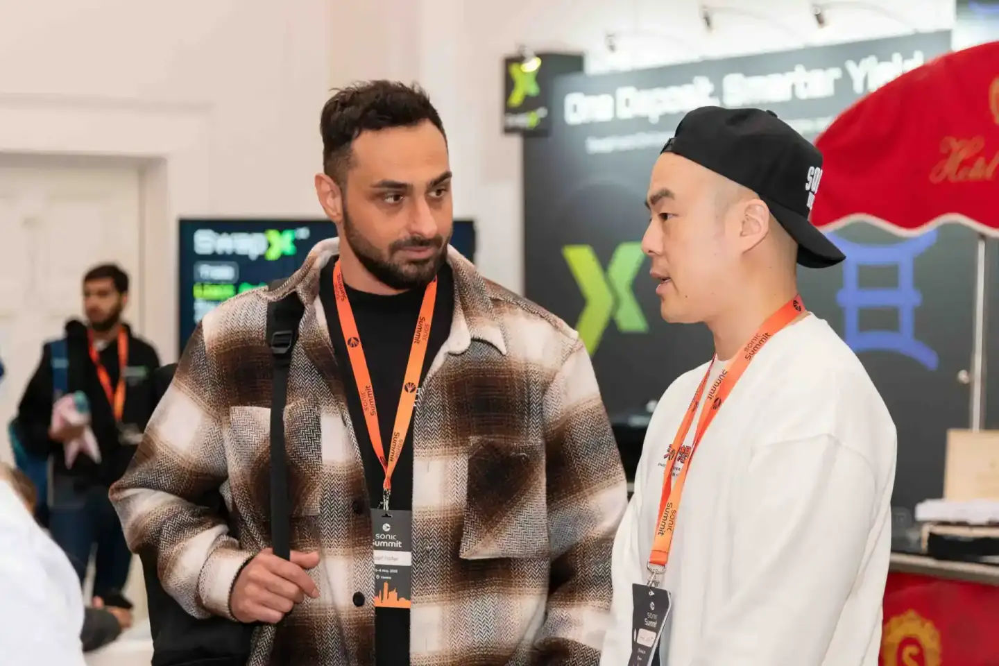 Zwei Besucher im Gespräch beim Sonic Summit Event in Wien, beide tragen Lanyards - professionelle Eventfotografie Wien