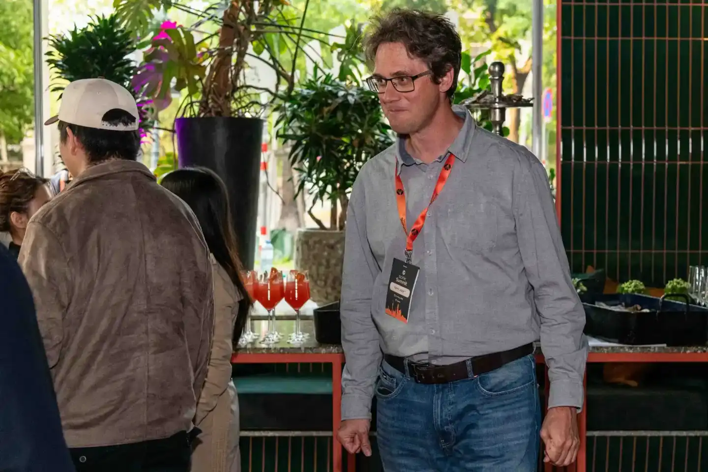 Eventfotograf dokumentiert Networking-Moment bei Sonic Summit Wien mit Badge und Cocktails im Hintergrund