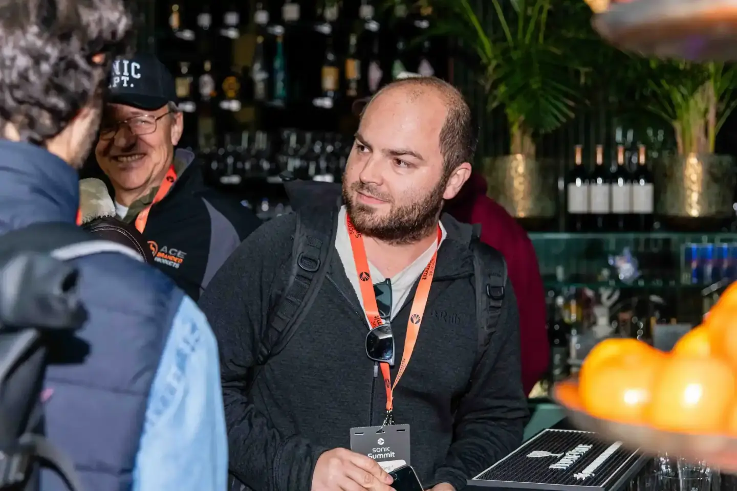 Eventfotograf dokumentiert Networking-Moment beim Sonic Summit in Wien mit Besuchern an der Bar