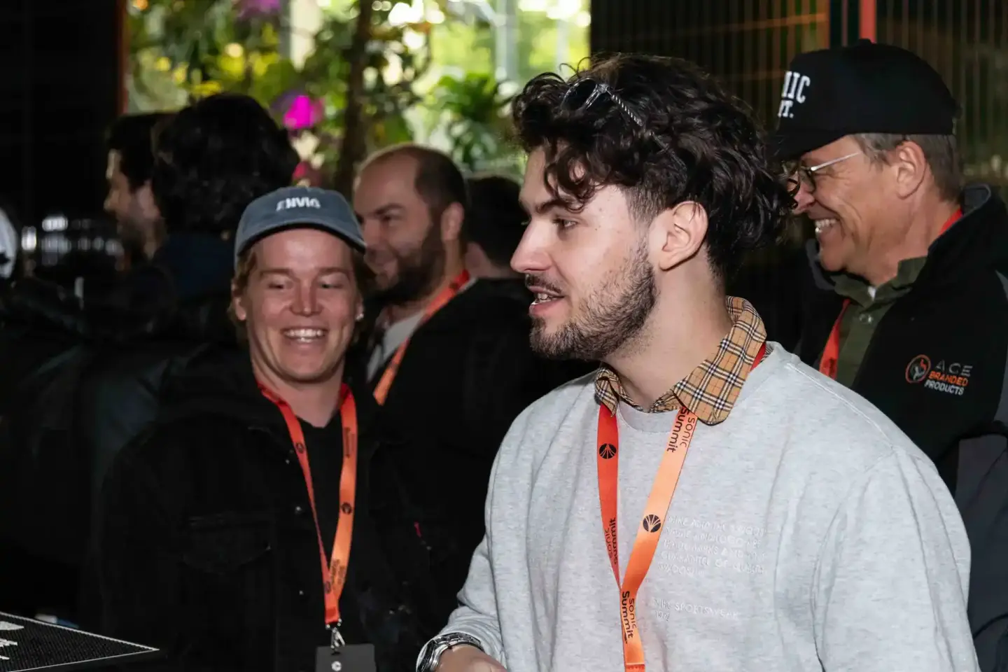 Besucher beim Sonic Summit Event Wien im Gespräch, tragen orangene Lanyards, Eventfotografie Wien