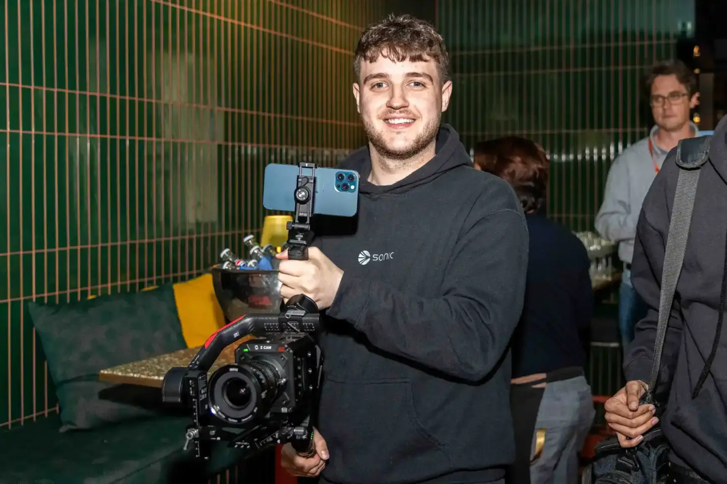 Eventfotograf demonstriert Smartphone-Halterung an Videokamera beim Sonic Summit Wien