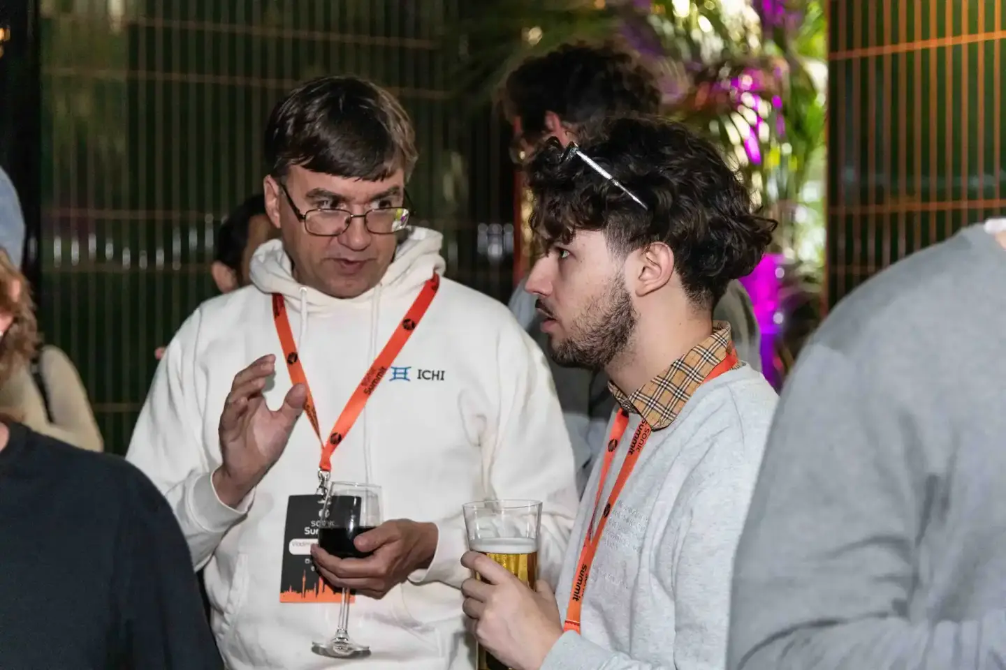 Zwei Männer mit Lanyards im Gespräch auf dem Sonic Summit Event in Wien – professionelle Eventfotografie