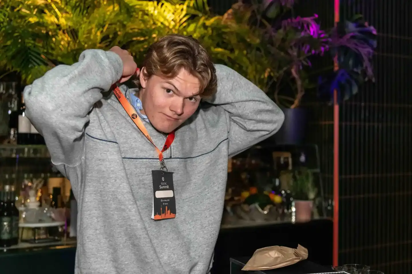 Junger Mann mit Lanyard beim Sonic Summit Event trägt graues Hoodie – Eventfotografie Wien