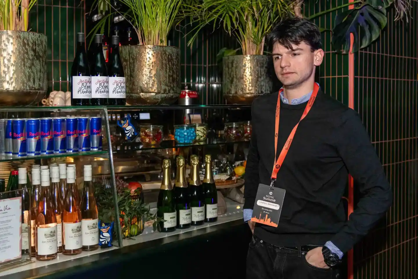 Eventfotograf dokumentiert einen professionellen Mann mit Lanyard an einer eleganten Getränkebar beim Sonic Summit in Wien