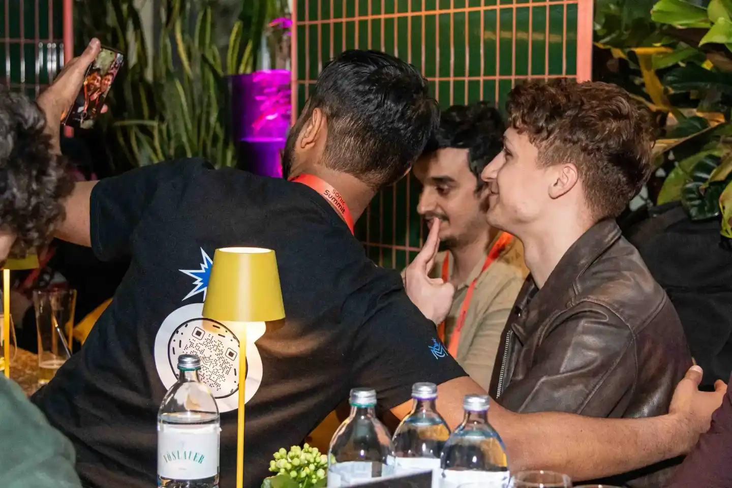 Drei Männer beim Sonic Summit Event in Wien, einer mit gelbem Lampenschirm auf dem Kopf, lachend an der Bar - Eventfotografie