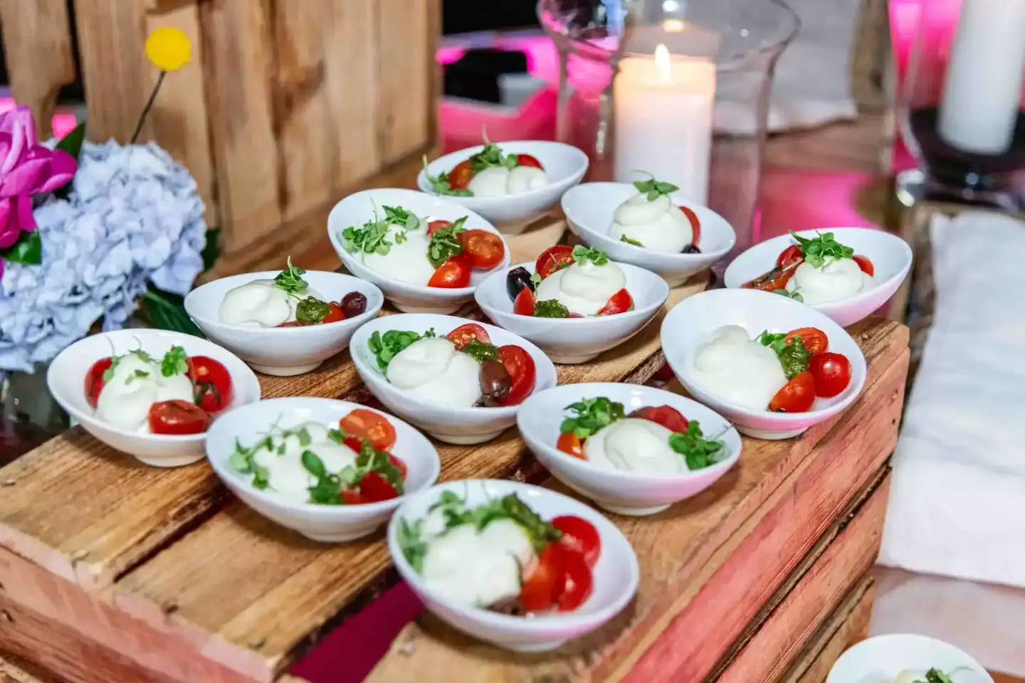 Elegante Caprese-Häppchen auf weißen Schüsseln bei einem Firmenevent Wien - Eventfotografie mit floraler Dekoration