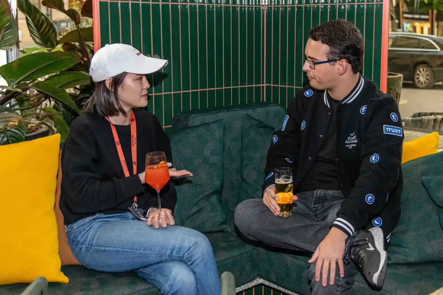 Zwei Personen sitzen auf grünem Sofa im Gespräch mit Getränken, Eventfotografie Wien