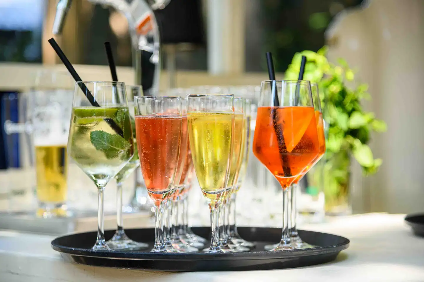 Nahaufnahme eines Tabletts mit Hugo, Rosé-Frizzante und Aperol Spritz an der Bar – Eventfotografie Wien